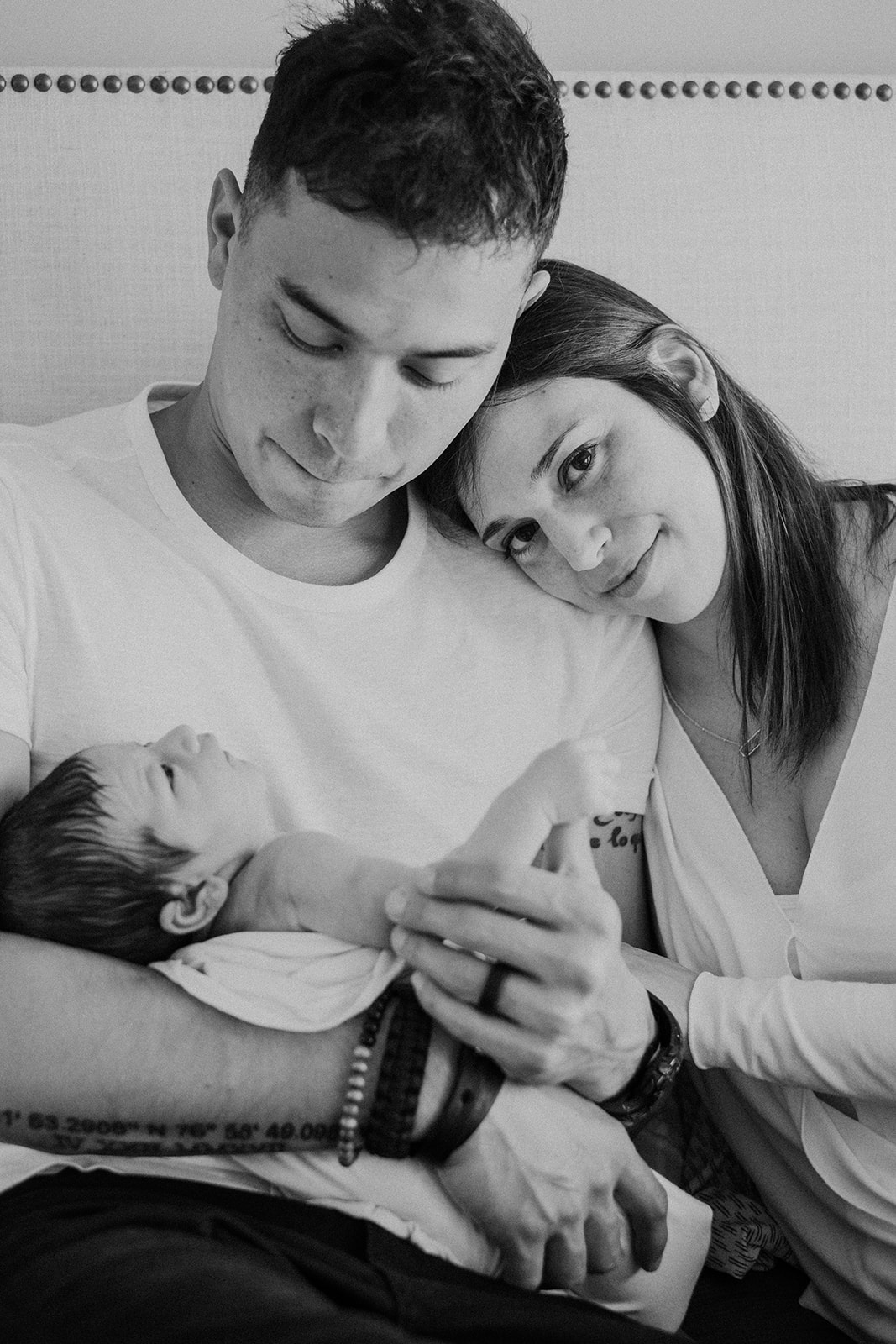 A father and mother hold their newborn son during an in home family photography session. 