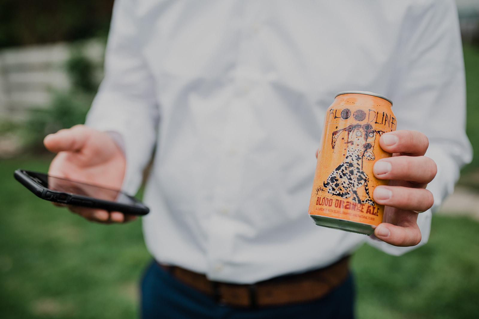 A groomsman holds a beer and his cell phone before a wedding at Blue Hill Farm in Waterford, VA. 