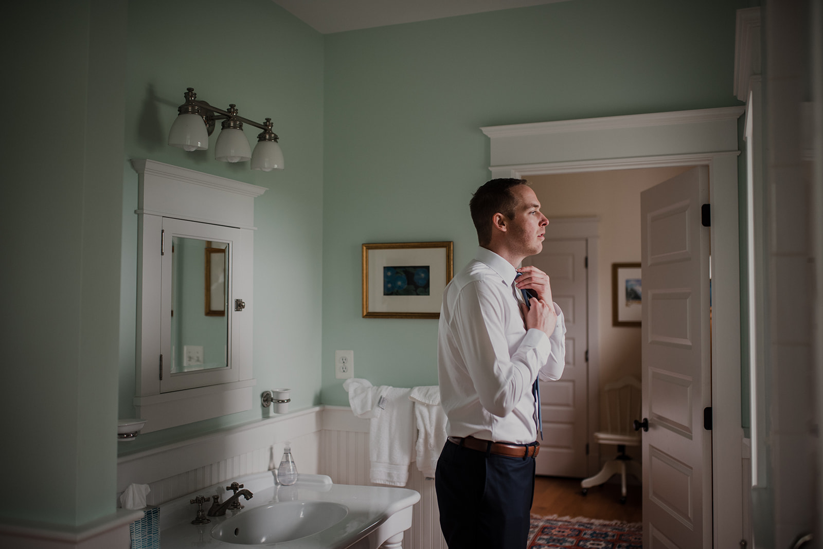 A groom gets ready before his outdoor spring wedding in the bathroom at the house at Blue Hill Farm in Waterford, VA. 
