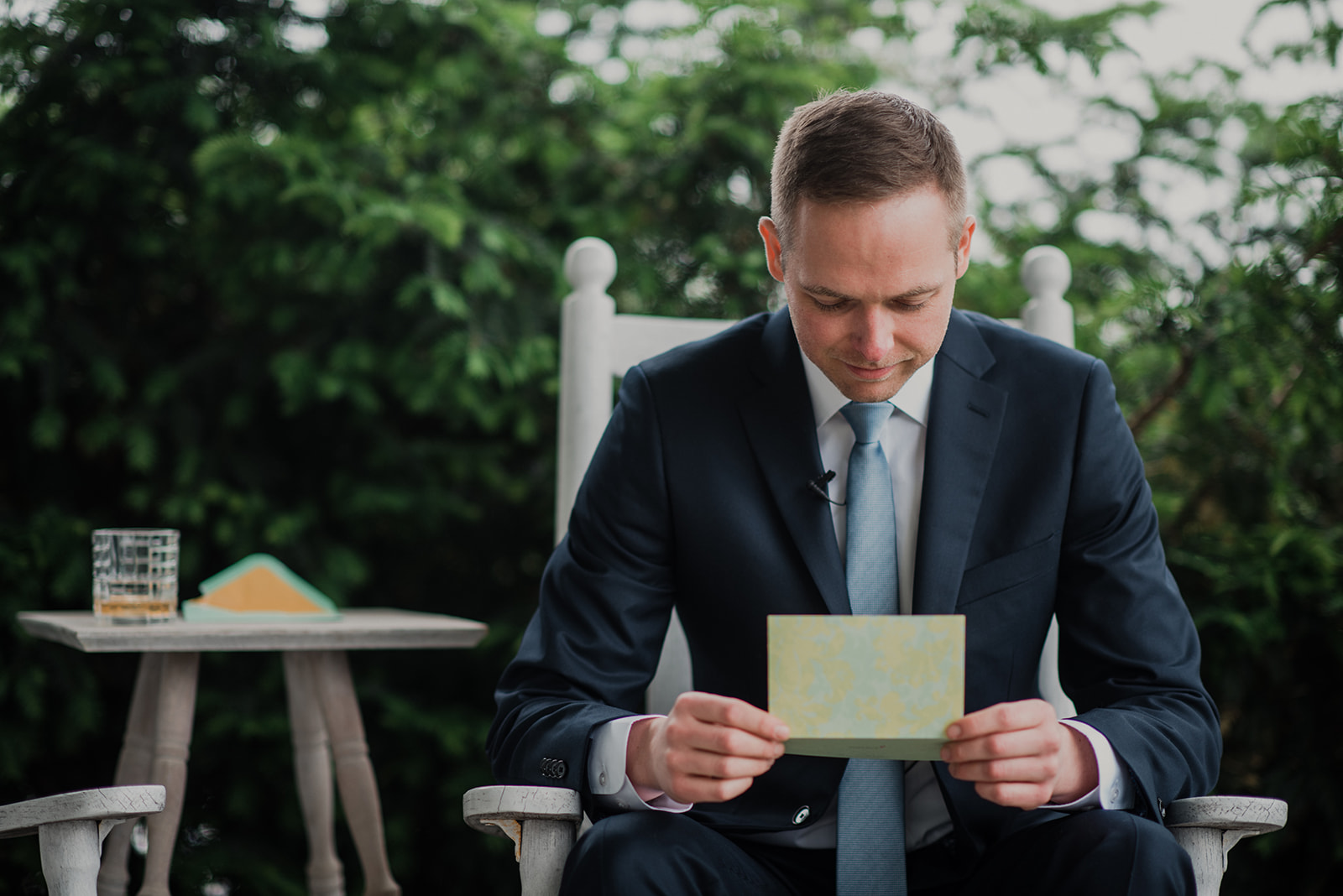 A groom reads a letter from his bride on the front porch of the house at Blue Hill Farm in Waterford, VA. 