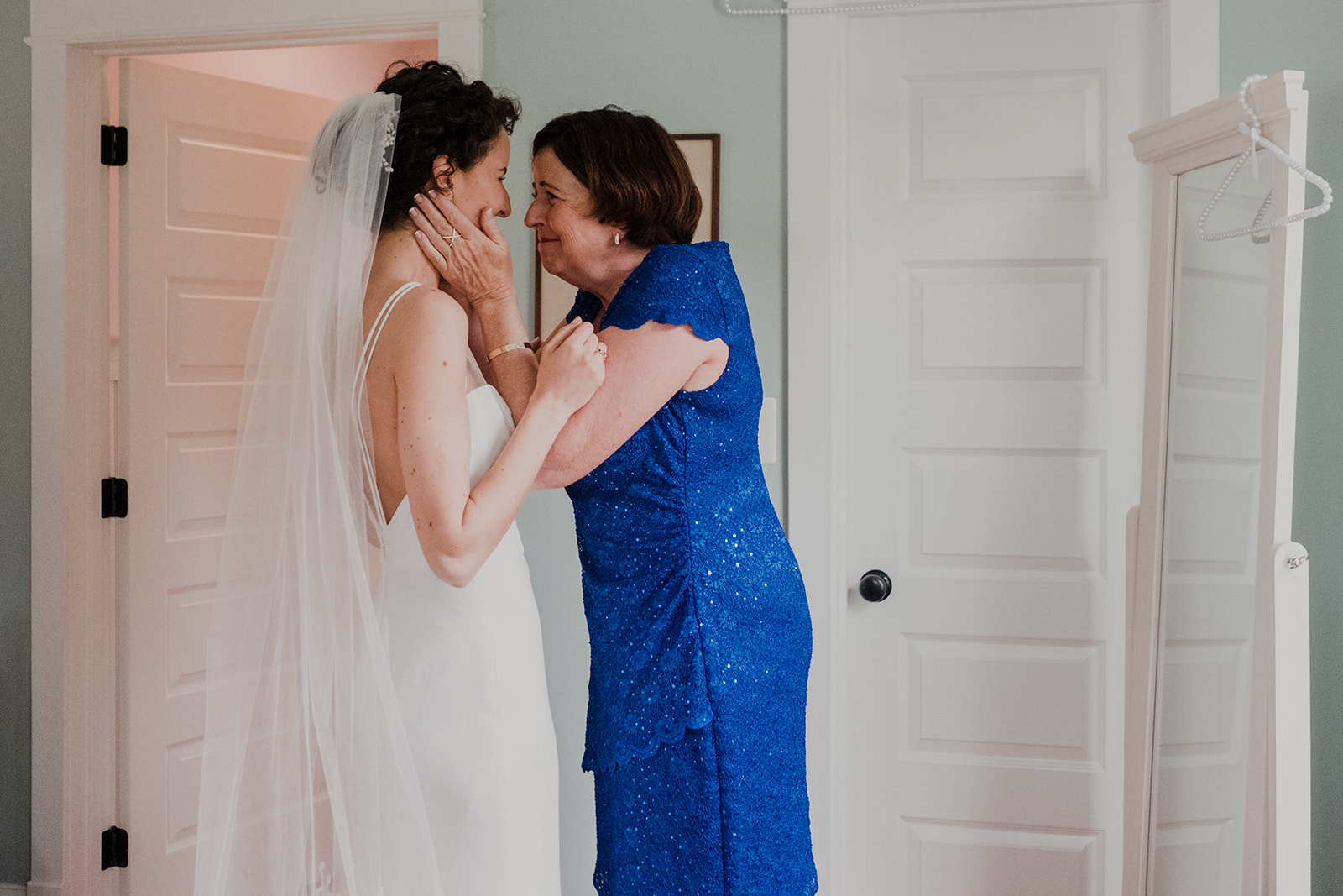 The mother of the bride holds her daughter's face in her hands on her wedding day at Blue Hill Farm in Waterford, VA.