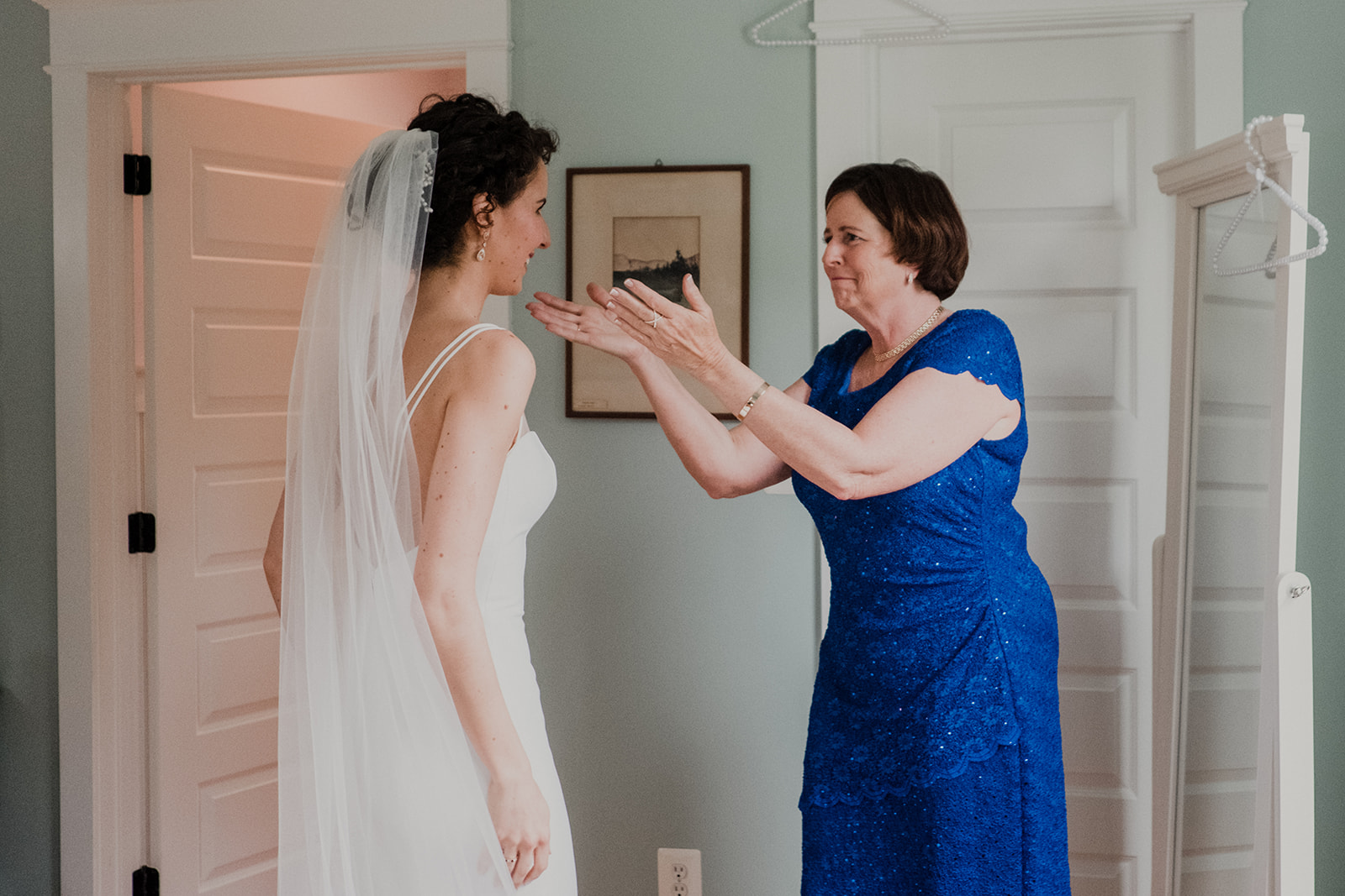 The mother of the bride reaches out to her daughter on her wedding day at Blue Hill Farm in Waterford, VA.