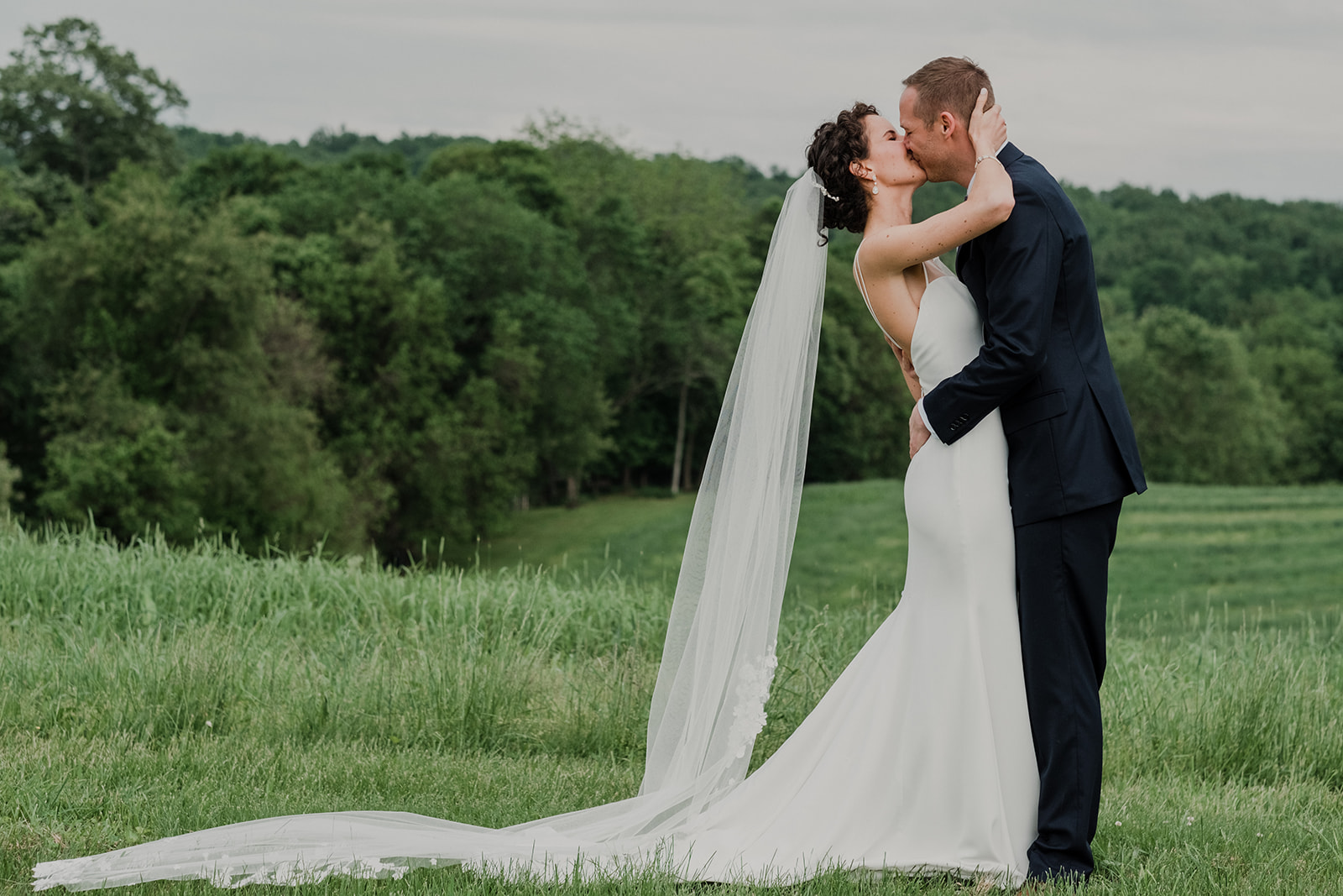 A bride and groom kiss during their first look before their outdoor wedding ceremony at Blue Hill Farm in Waterford, VA.