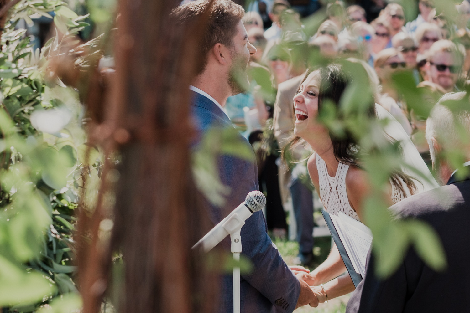 bride and groom laugh big during wedding ceremony as they exchange vows