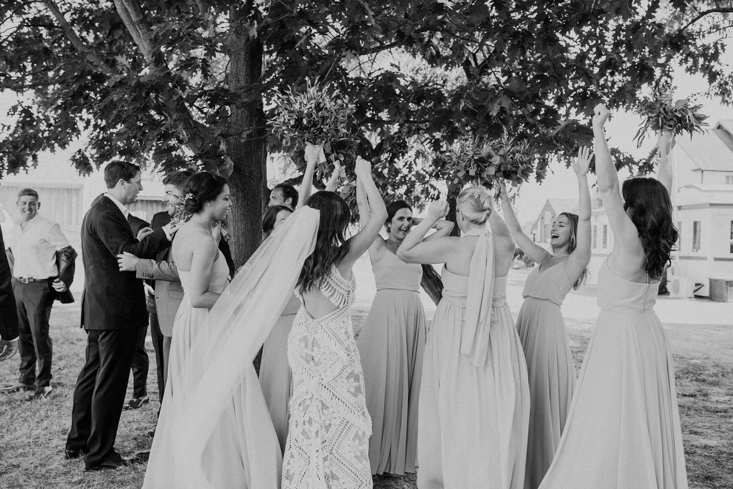 bridesmaids lift their hands in celebration at the end of the wedding ceremony