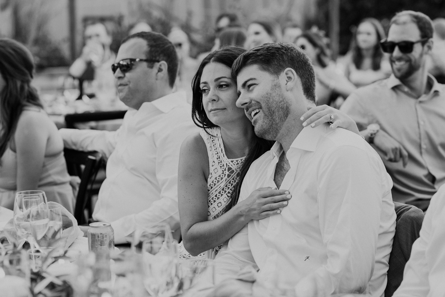 bride and groom hold each other close while listening to toasts