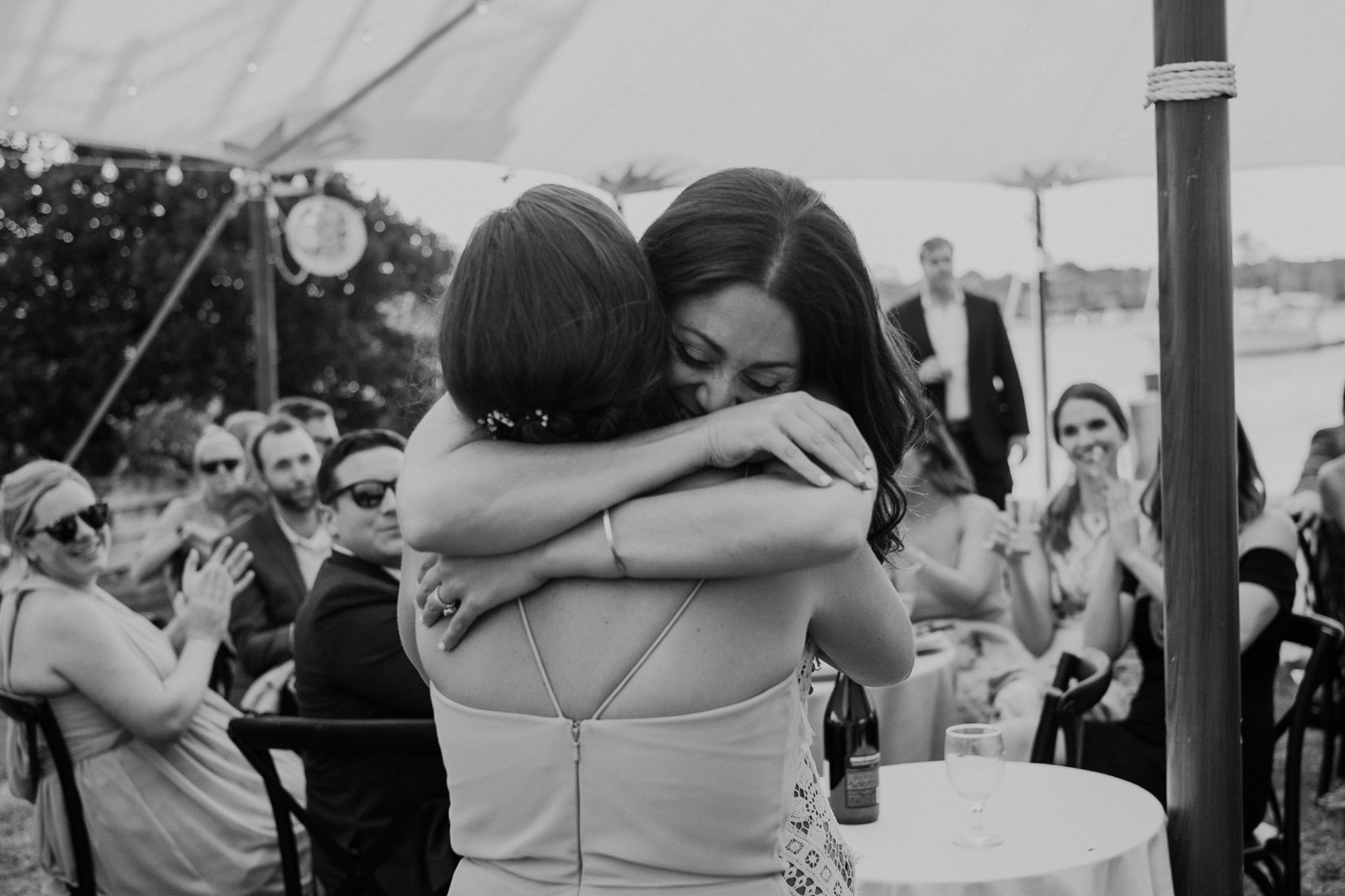 bride hugs maid of honor after wedding toast