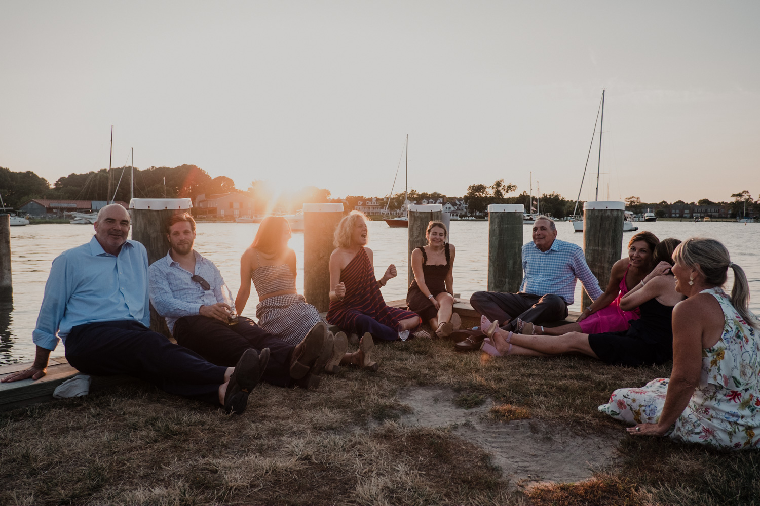 wedding guests sit on the docks during sunset relaxing at the Chesapeake Bay Maritime Museum