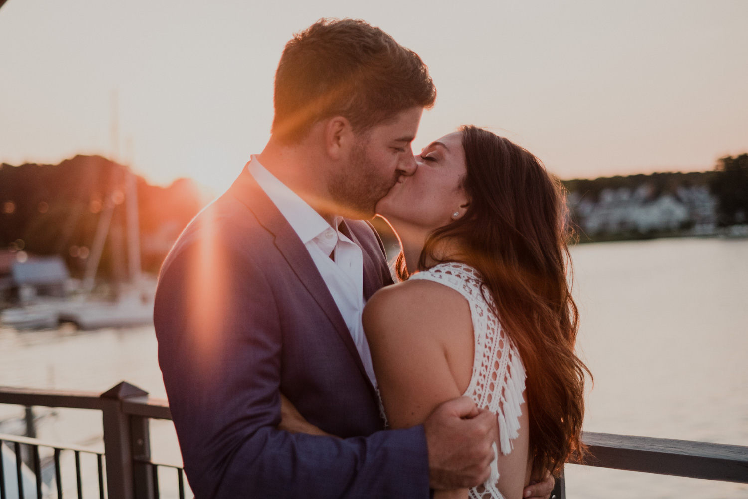 bride and groom kiss during sunset portraits with the bay in the background