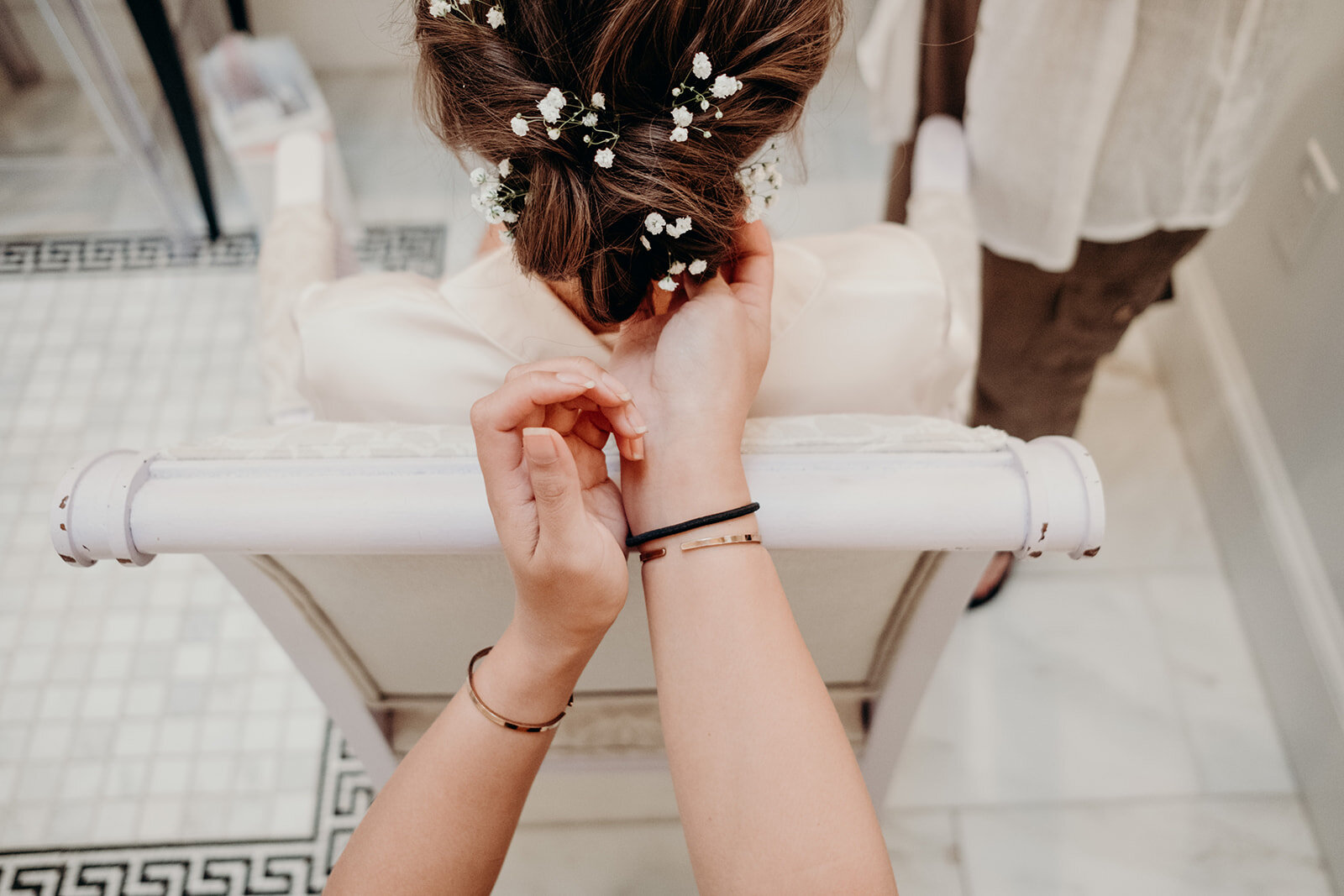A hair stylists adds the finishing touches of baby's breath to the bride's hair at the Birkby House in Leesburg, VA.  