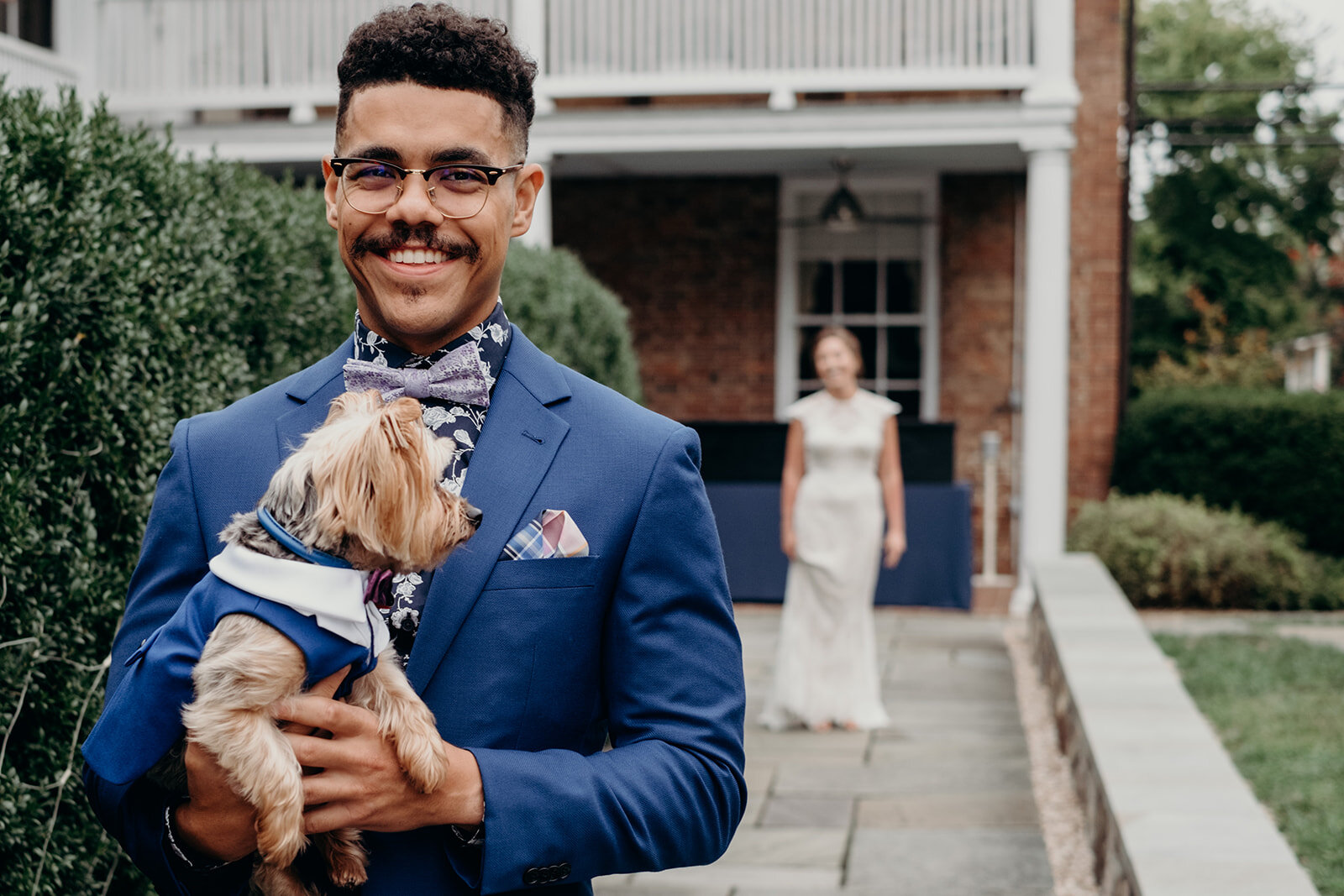 A groom holds his ring bearing pup while he waits for his bride during a first look at Birkby House in Leesburg, VA. 