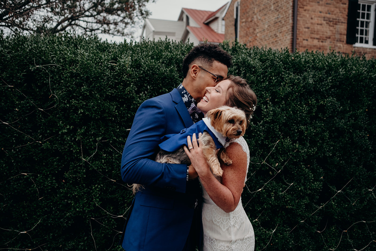 A bride, groom and their ring-bearing pup snuggle during their first look at Birkby House in Leesburg, VA. 