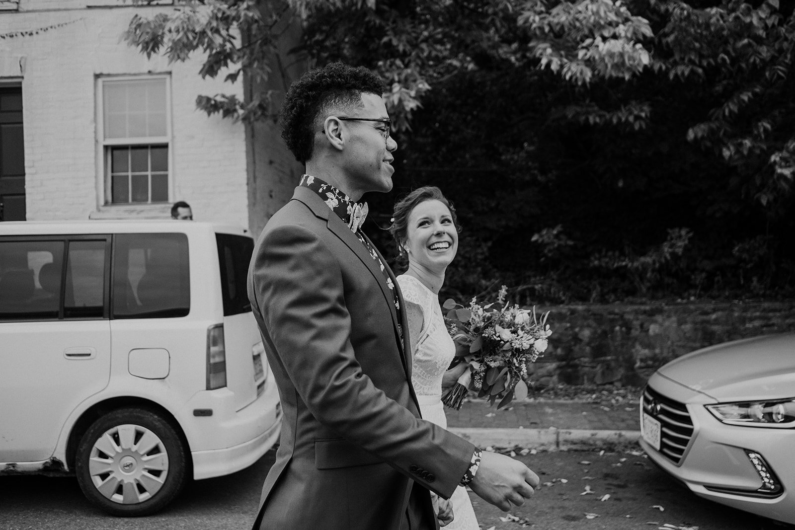 A bride and groom share a laugh as they walk down the street in Leesburg, VA.