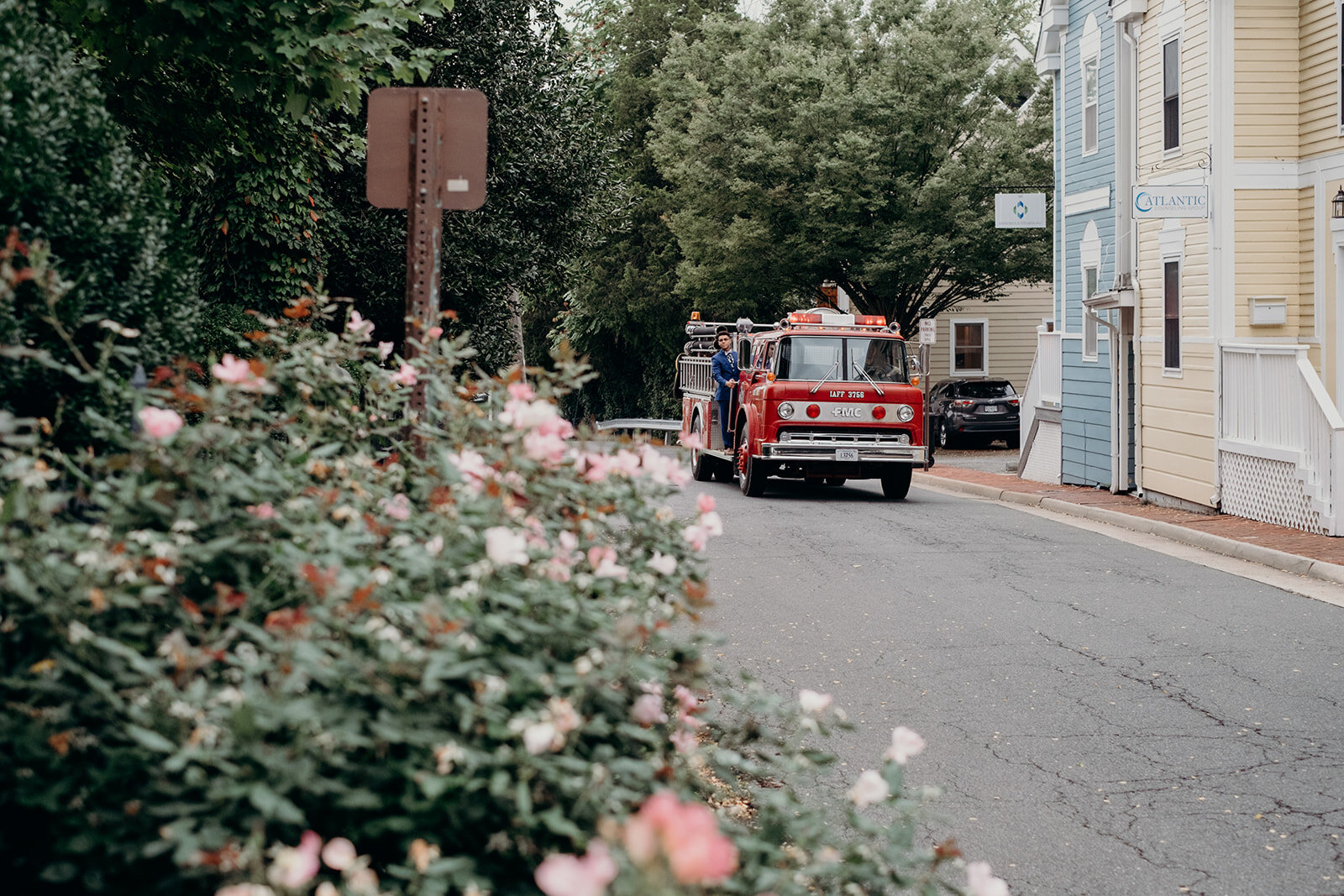 A groom rides a firetruck to his outdoor wedding ceremony at Birkby House in Leesburg, VA.