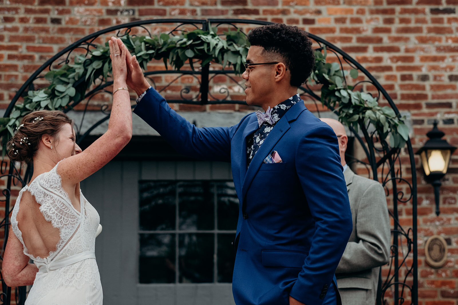 A bride and groom high five one another after exchanging vows during their outdoor wedding ceremony at Birkby House in Leesburg, VA. 