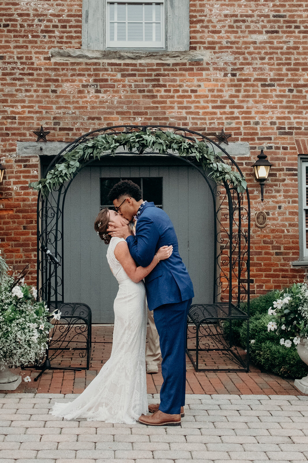 A bride and groom share their first kiss as husband and wife after their outdoor wedding ceremony at Birkby House in Leesburg, VA.