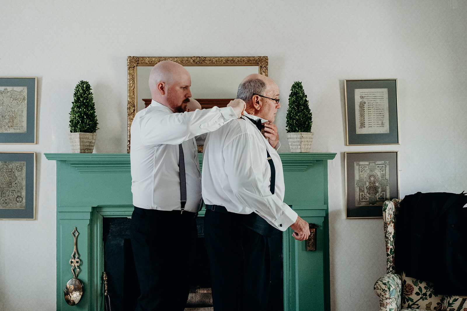 The groom helps his father with his tie before his outdoor farm wedding ceremony.