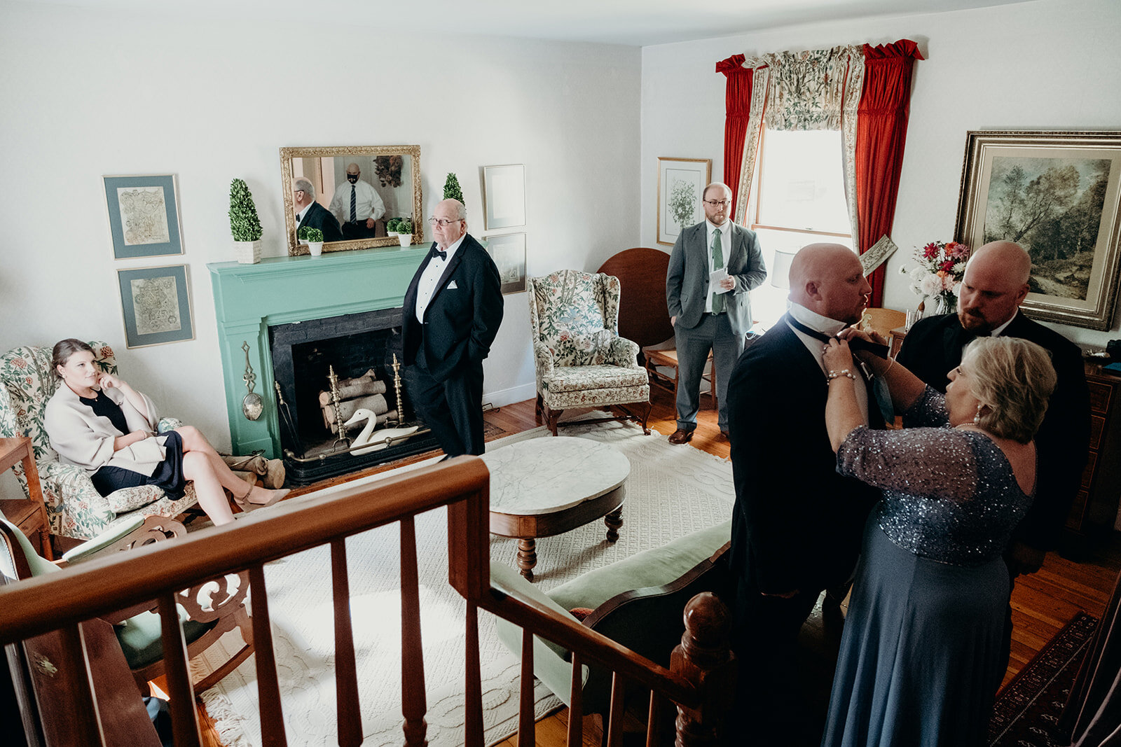 Various family members get ready in the living room of an old farmhouse before the outdoor wedding ceremony. 