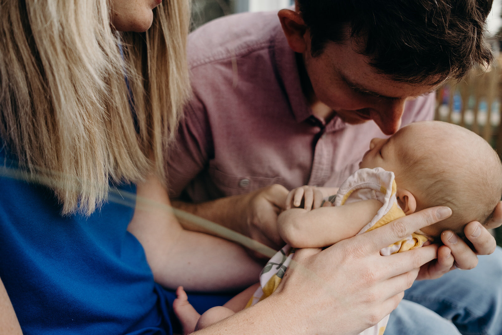  A father nuzzles his newborn baby girl. 