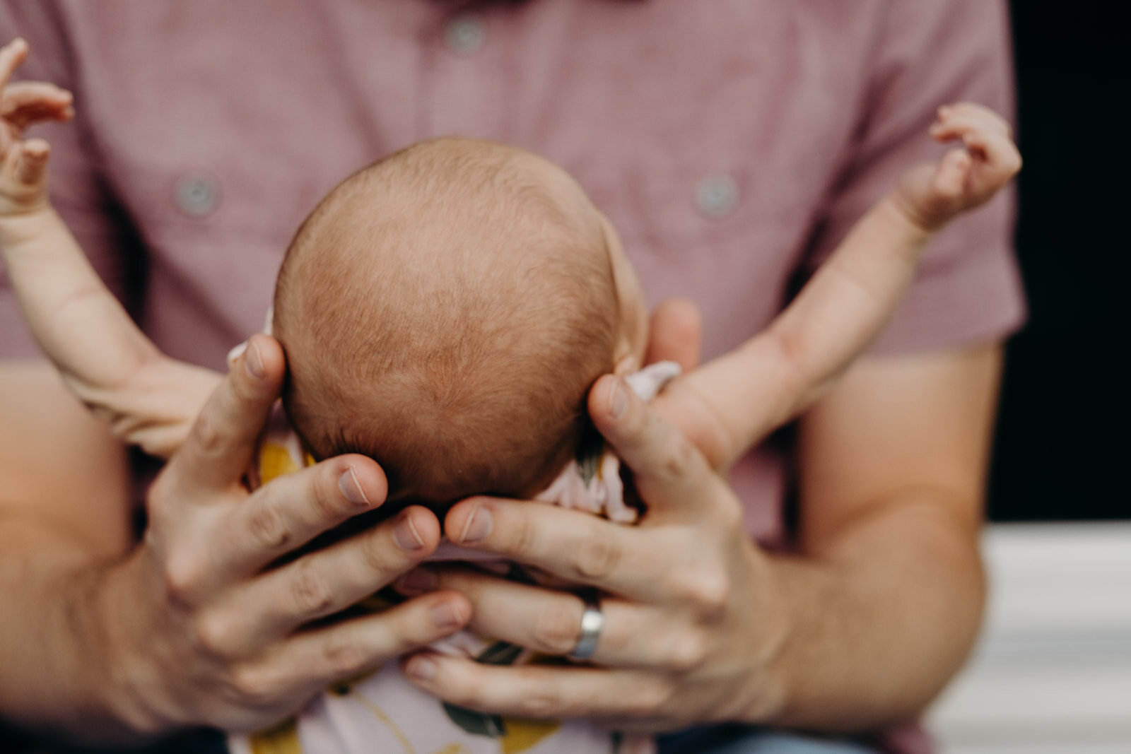 A father holds his newborn baby girl. 