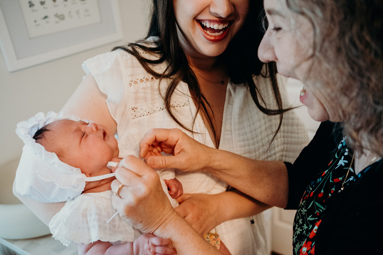 A grandmother puts a bonnet on her granddaughter before her Jewish naming ceremony.
