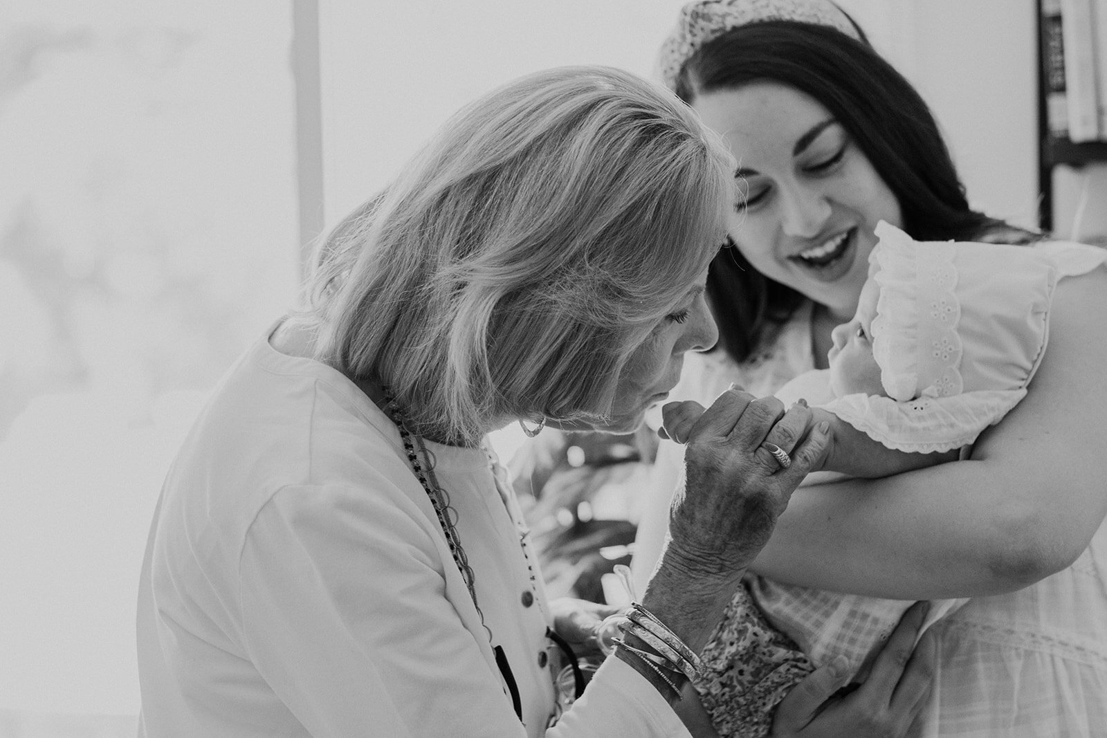 A grandmother kisses her great granddaughter before a Jewish naming ceremony.