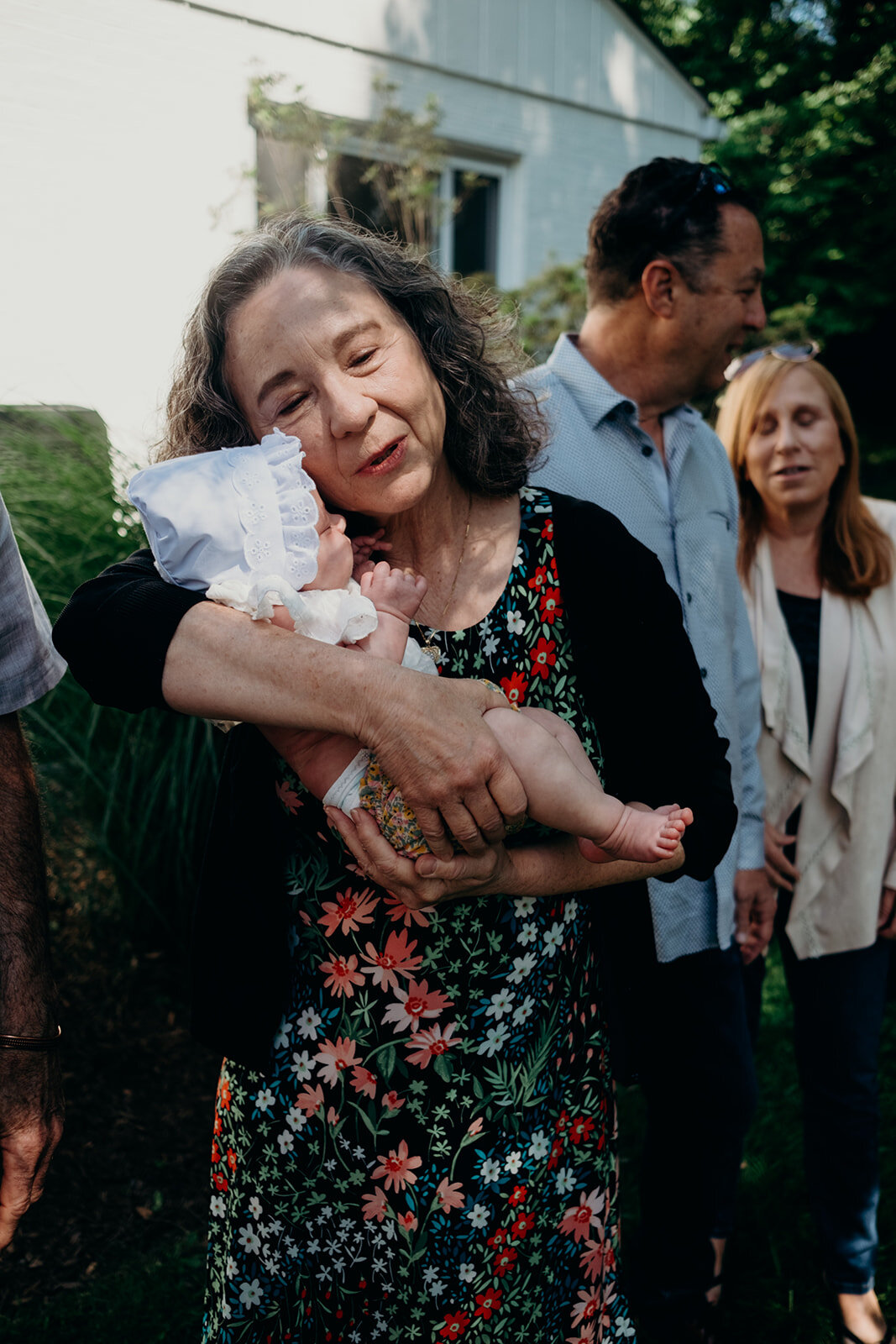A grandmother snuggles her granddaughter during a Jewish baby naming ceremony.