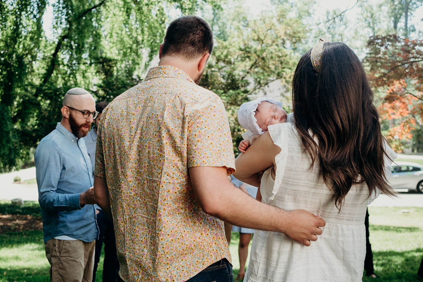 A husband embraces his wife during their daughter's Jewish baby naming ceremony.