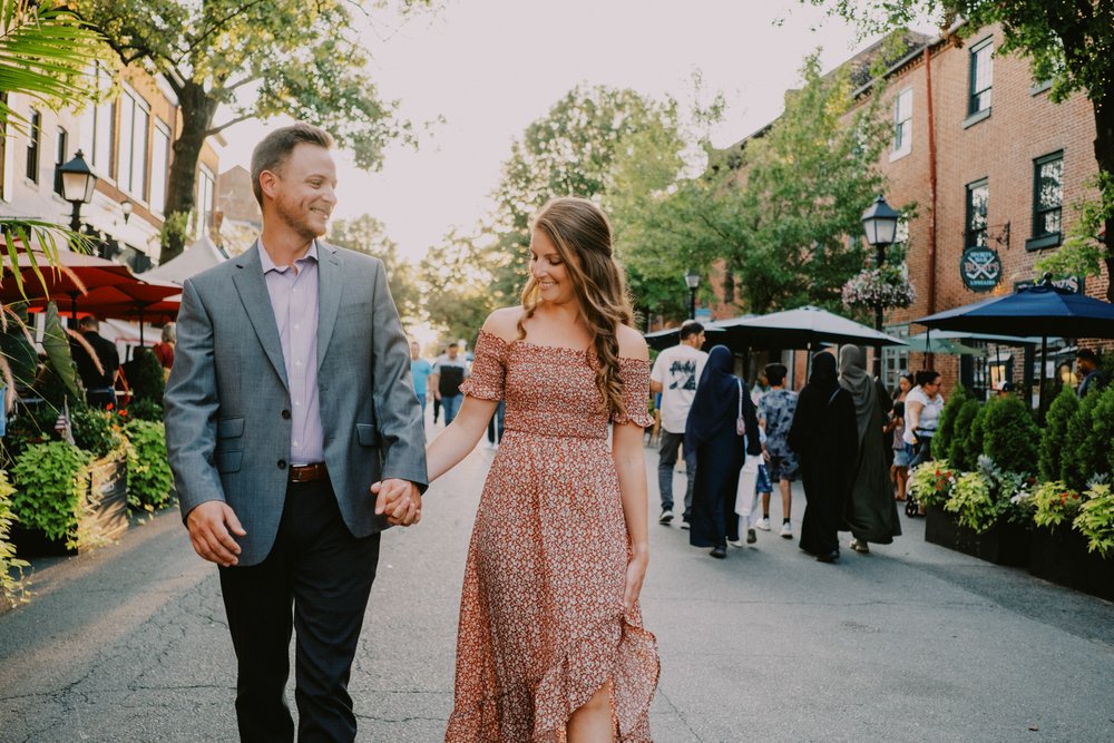 Old town engagement session couple walking through crowded King Street