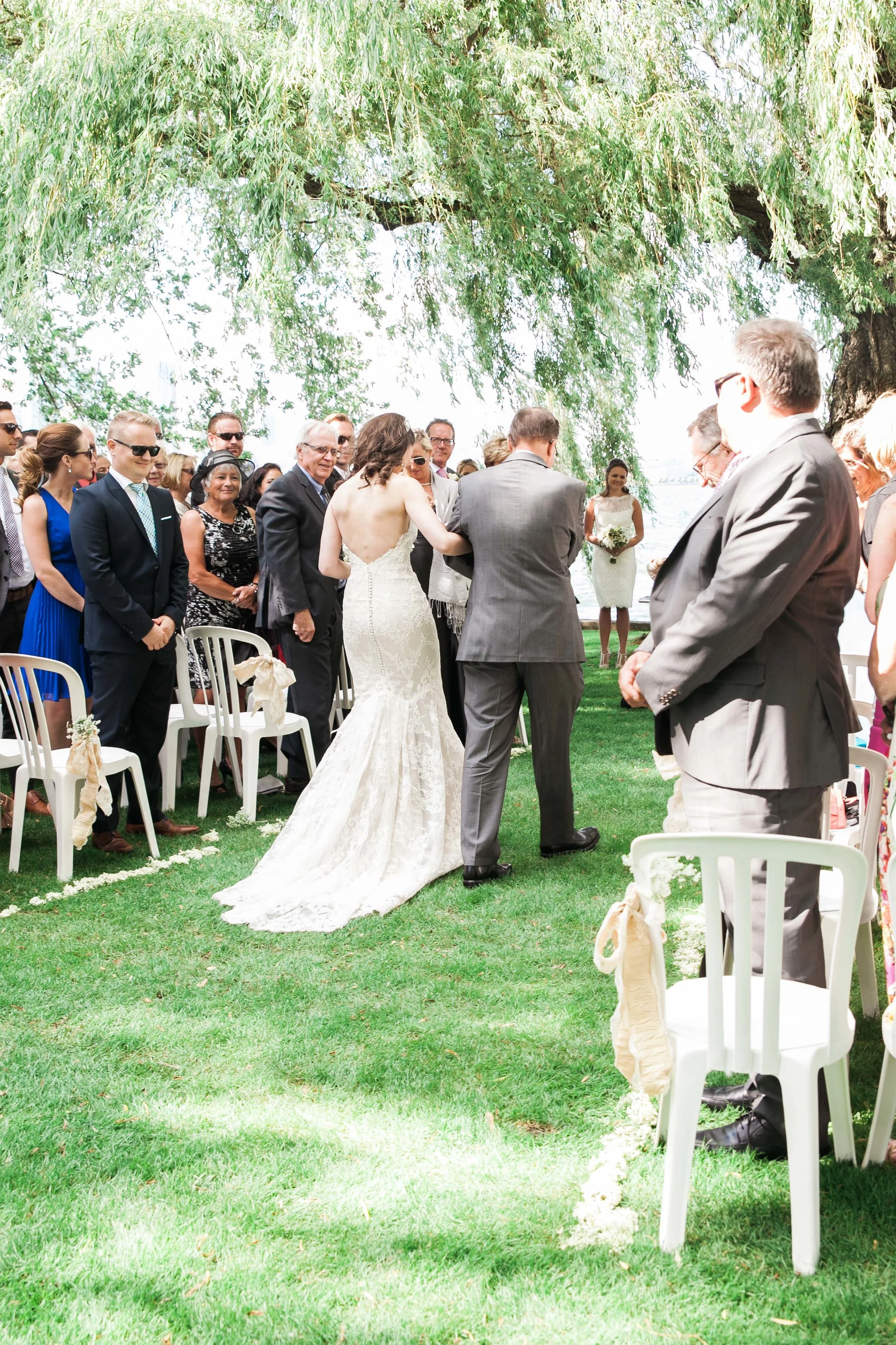 Bride and dad walking towards groom at summer Toronto wedding