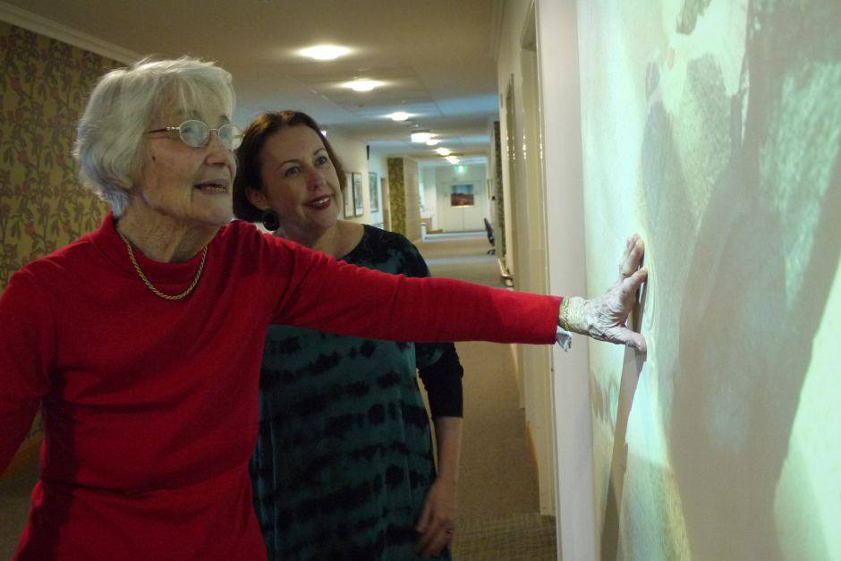Dementia design specialist Debbie de Fiddes (right) chats with Marjorie Hartley at the interactive wall. Photo Credit: ABC News / Rebecca Turner