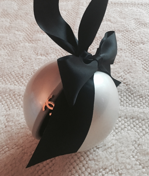 A Chanel pearl clutch with a black satin bow handle.