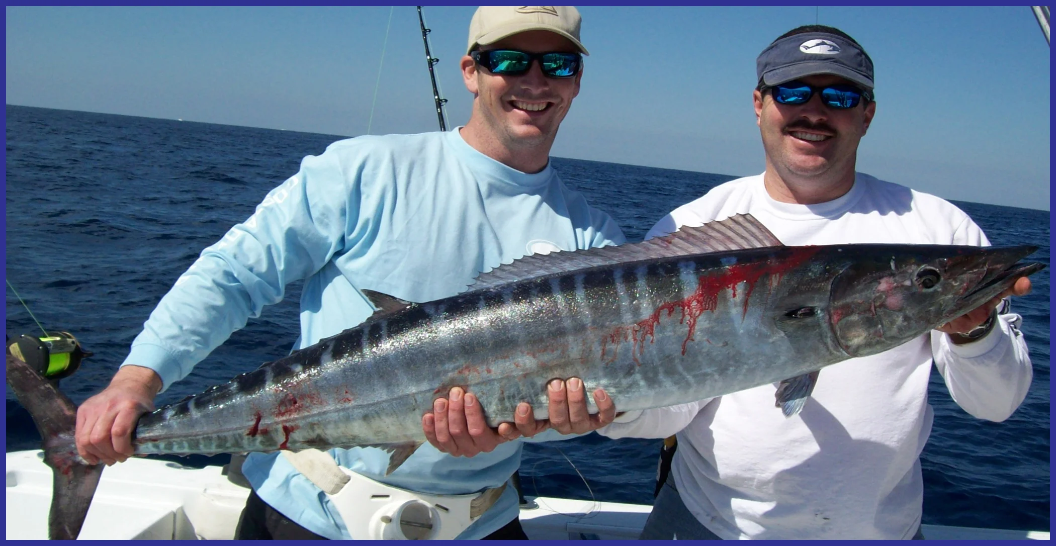 large wahoo held by two fisherman