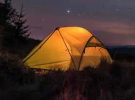 Emergency light bulb hung in tent.