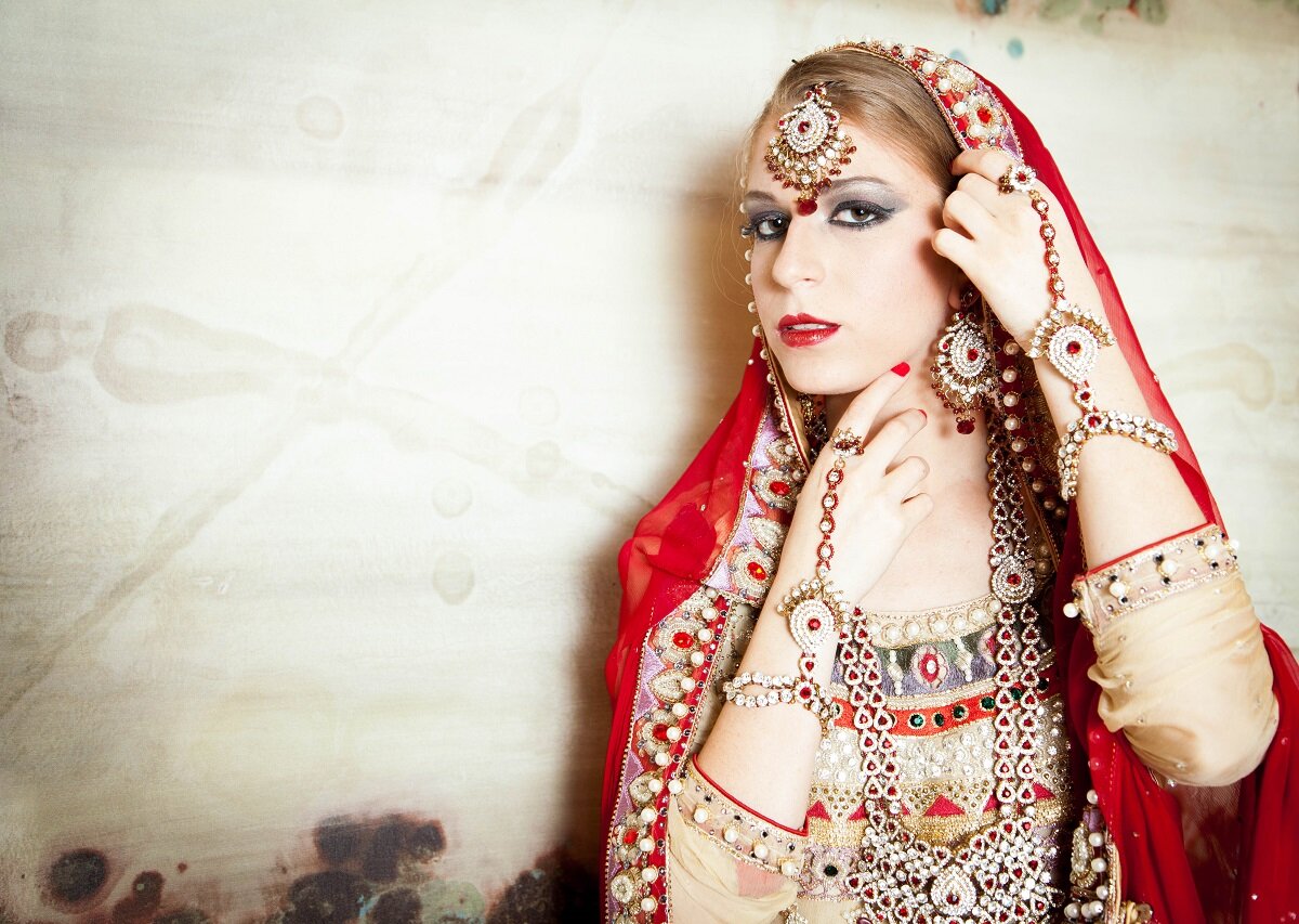  editorial image of Caucasian girl wearing red saree and traditional jewelry 