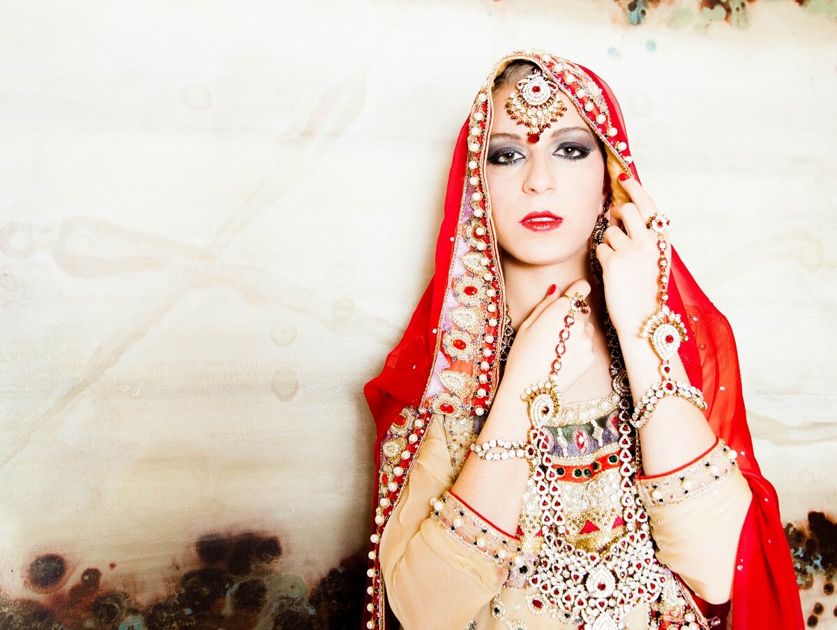  editorial image of girl wearing red sari and traditional indian jewelry 