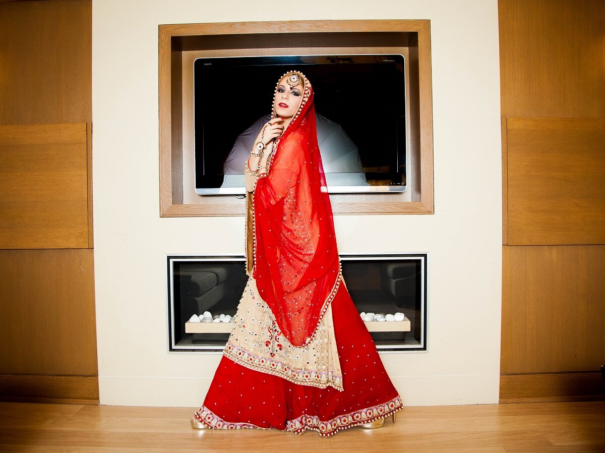  editorial image created for magazine of full length image of young woman wearing red saree 