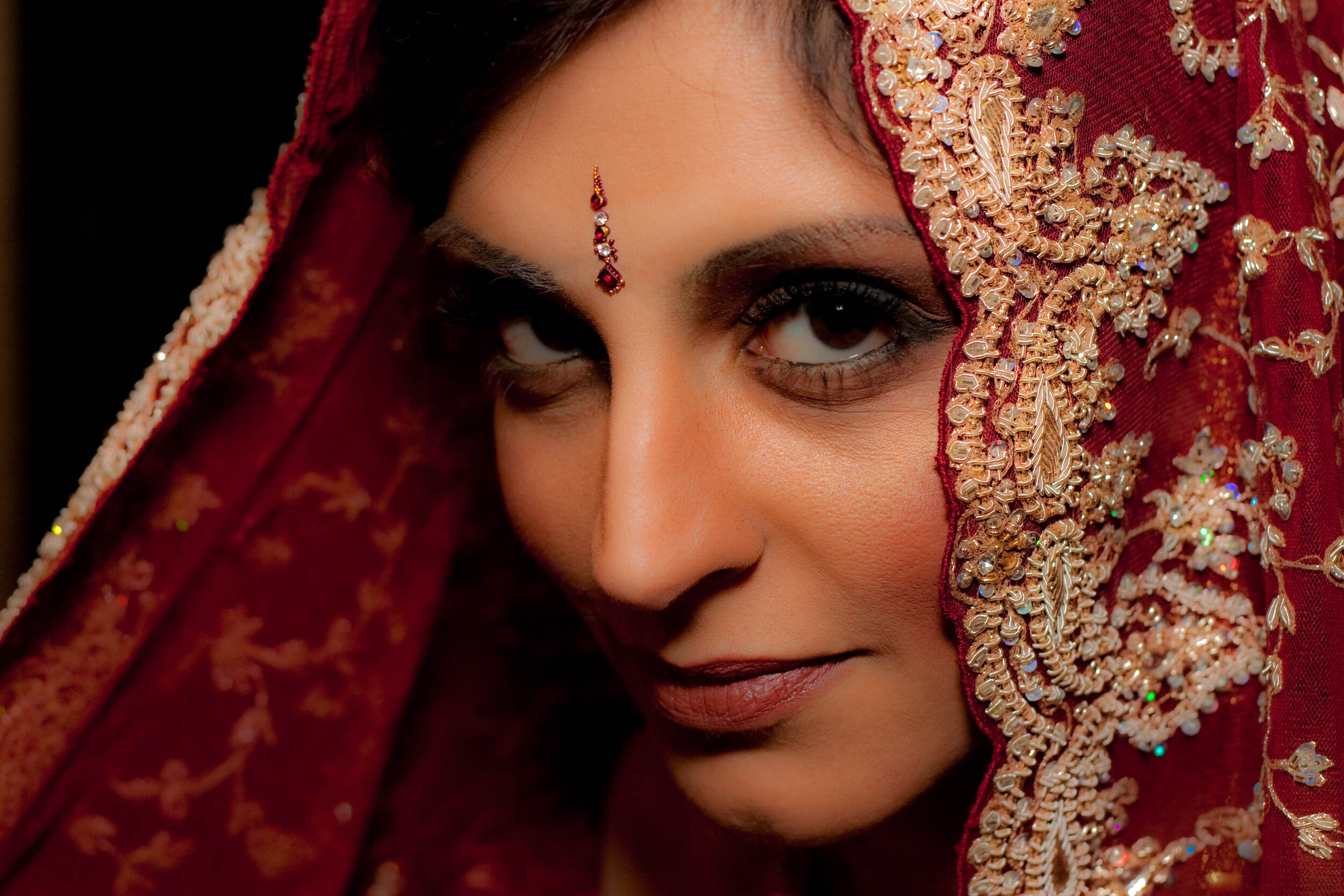 high fashion editorial image of south asian bride dressed in a red saree 