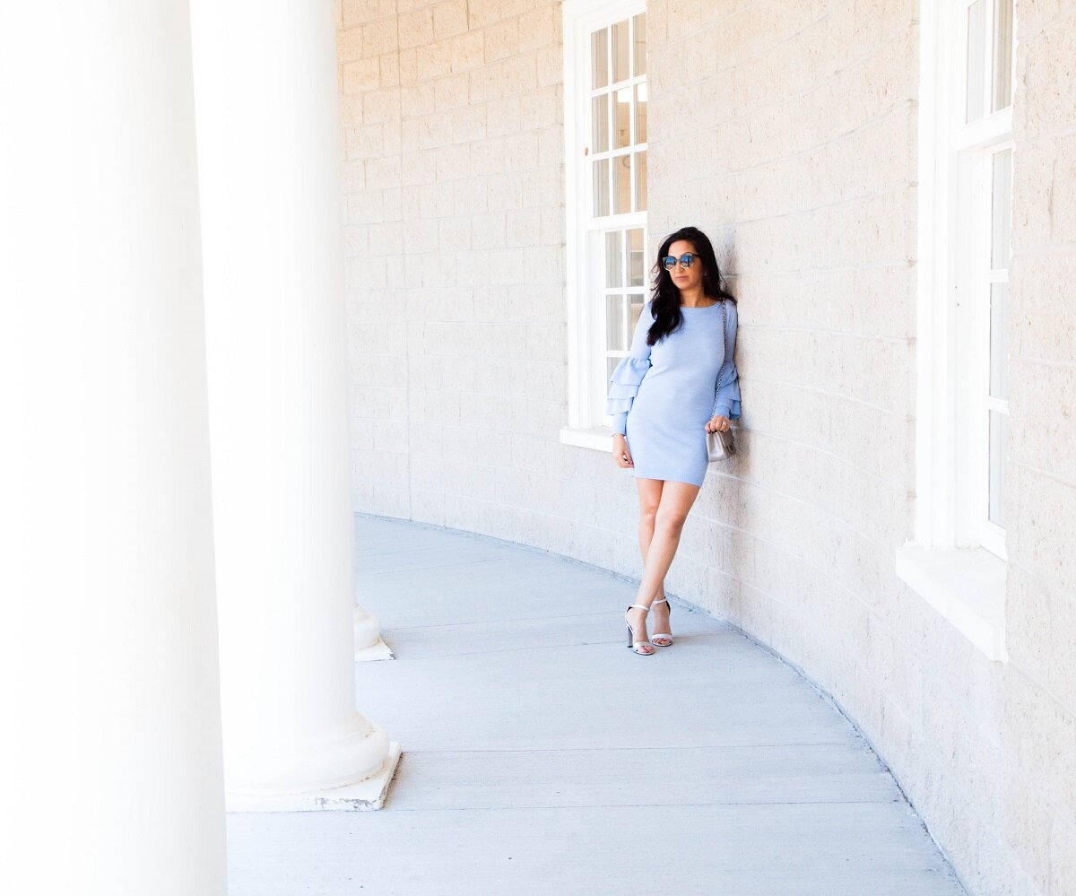  young woman stands elegantly near pillars 