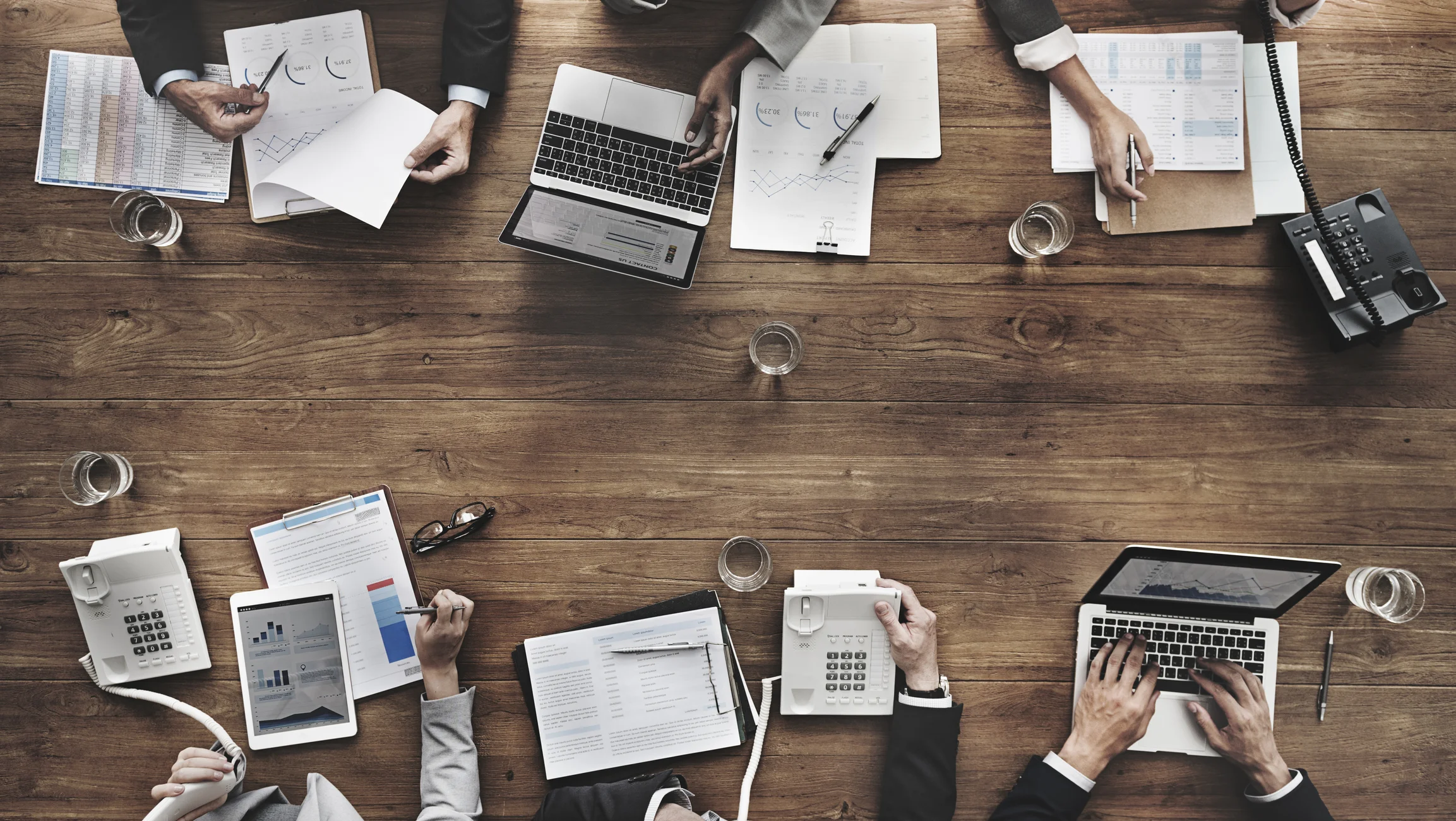 Looking down on a meeting table of six with materials & technology.