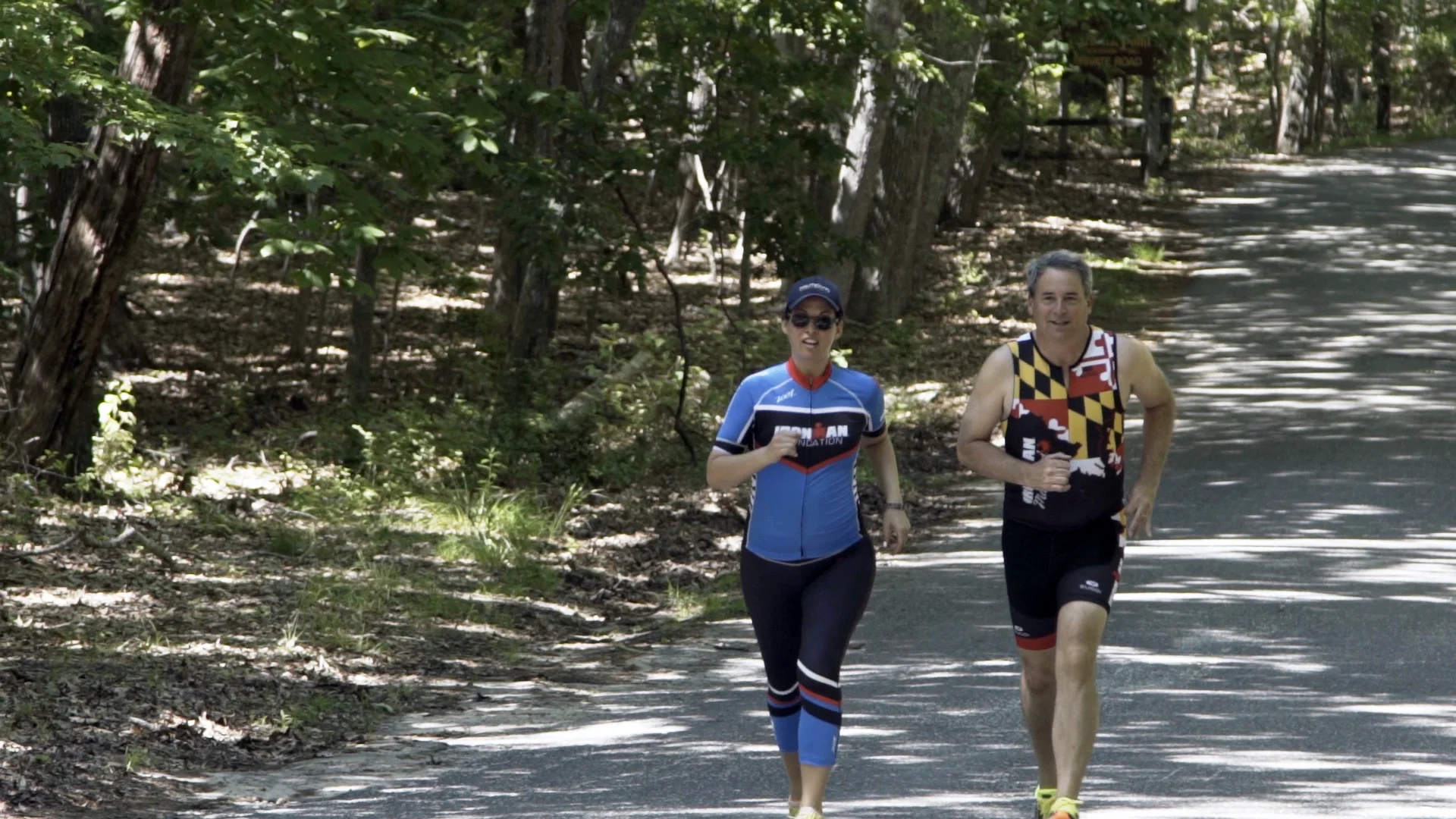 Kevin and training partner running along a tree lined road, in training for triathlons.
