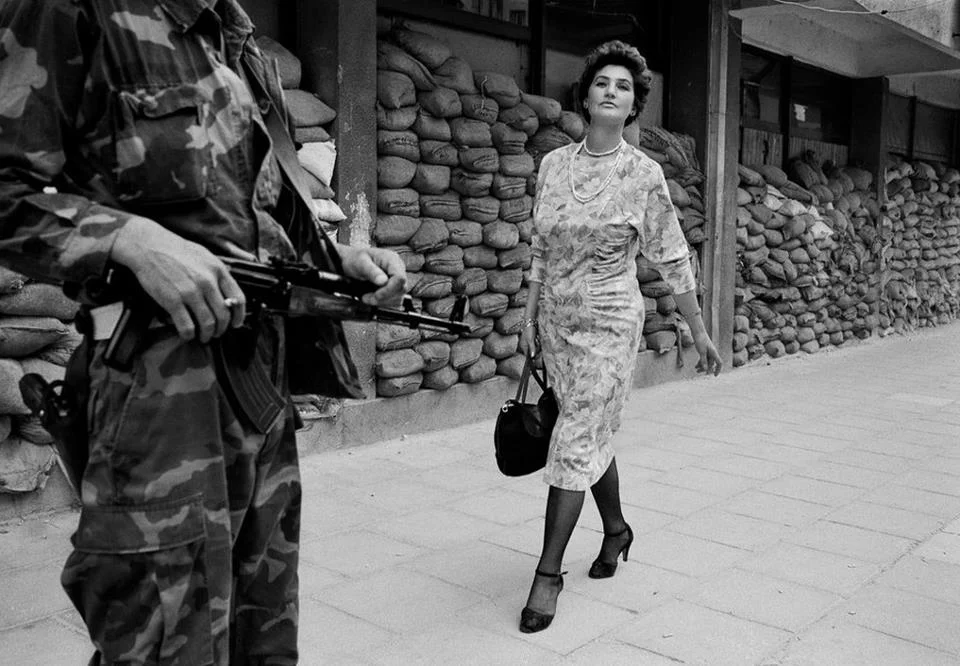 SARAJEVO, BOSNIA - 1995: In the dangerous suburb of Dobrinja, Meliha Varesanovic walks proudly and defiantly to work during the Siege of Sarajevo, 1995. Her message to the watching Serb gunmen who surround her city is simple, "you will never defeat us." Tom Stoddart/Reportage by Getty Images