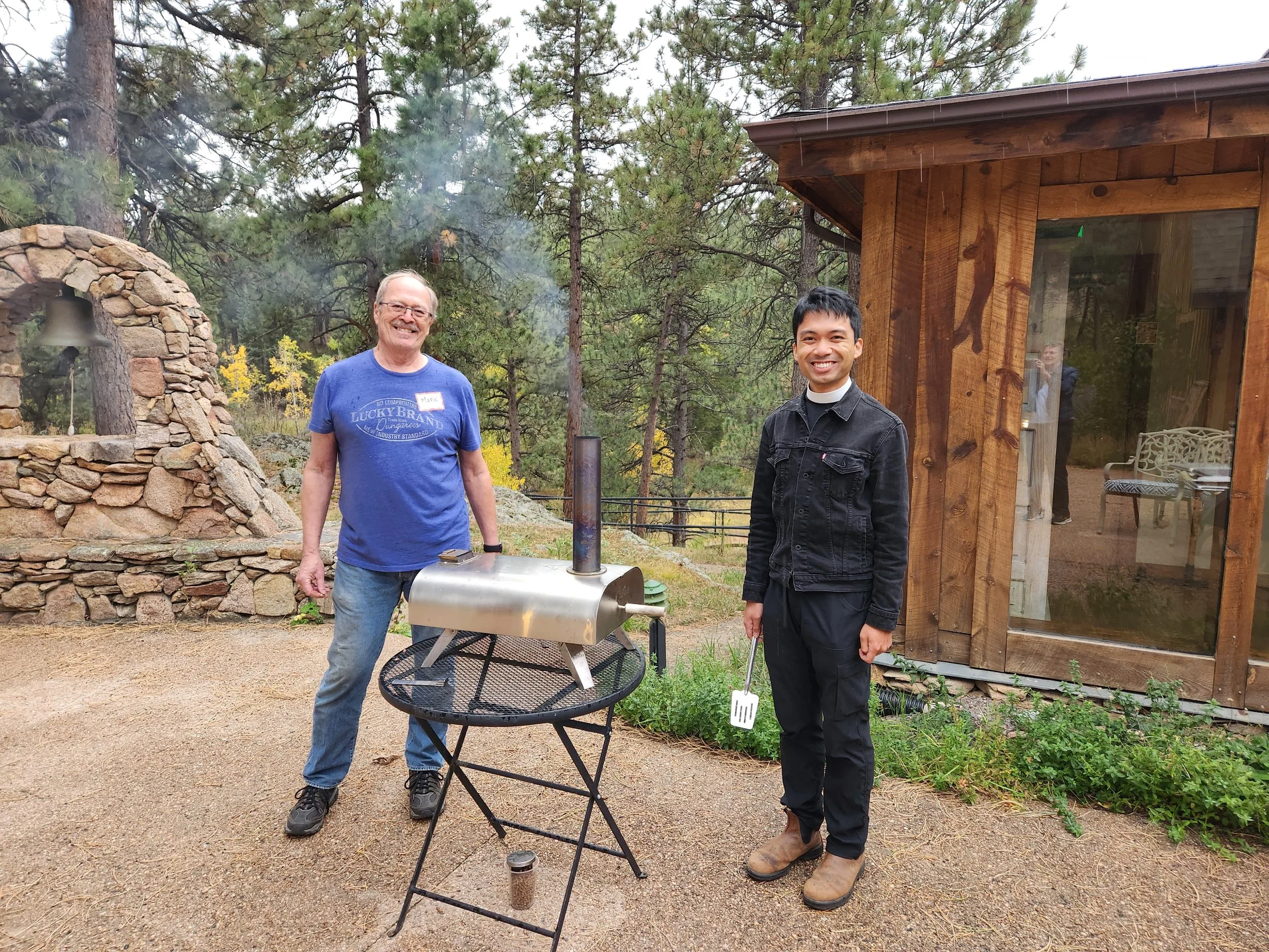 Rev. Chris cooking pizzas in his new pizza oven for the Community Garden party.