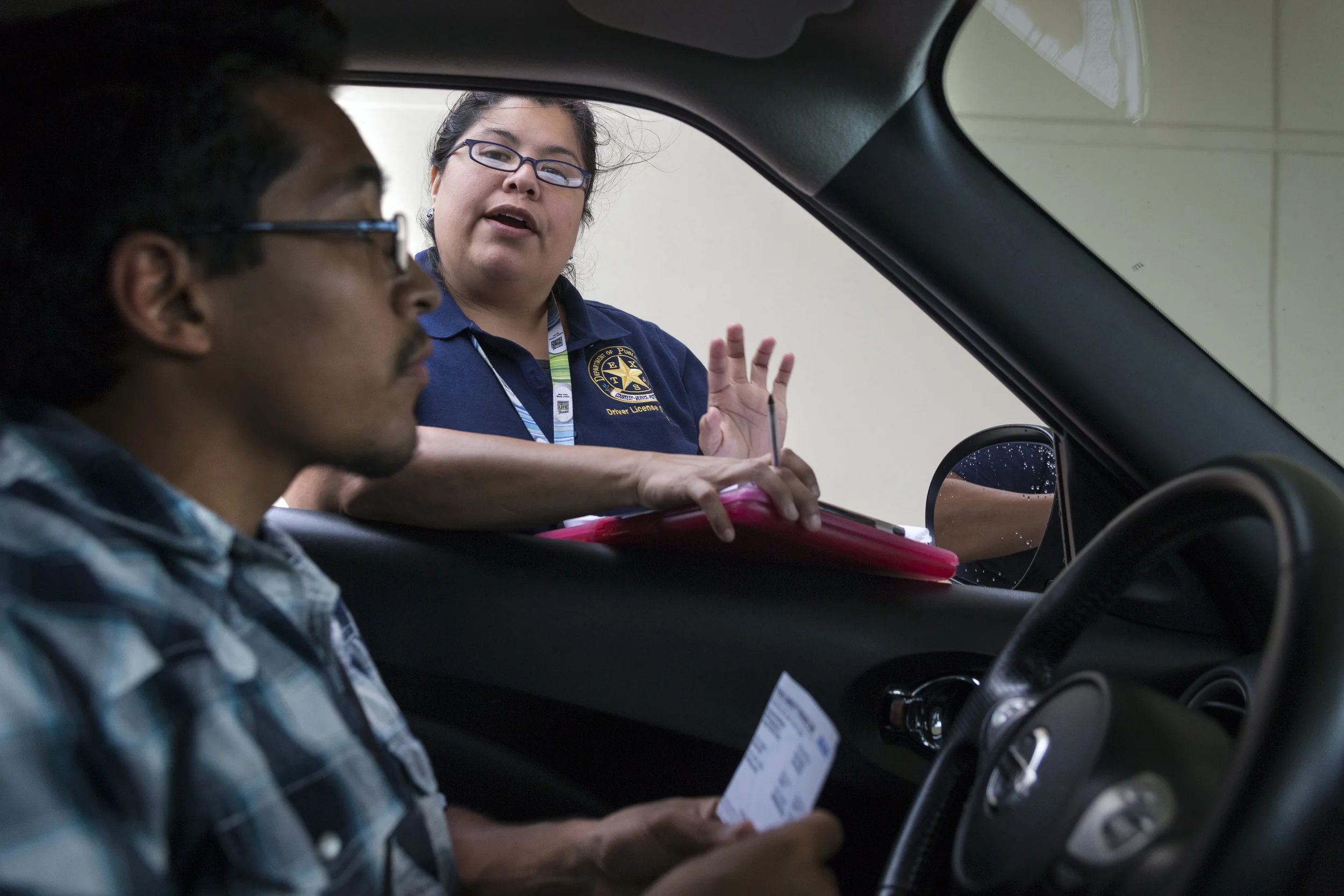 AUSTIN, TEXAS - August 20, 2015: A Texas Department of Public Safety employee tells Joseph that he is missing a document required for his driving test. Joseph needs his drivers' license to work and pay for his classes. Miguel Gutierrez Jr./KUT News.