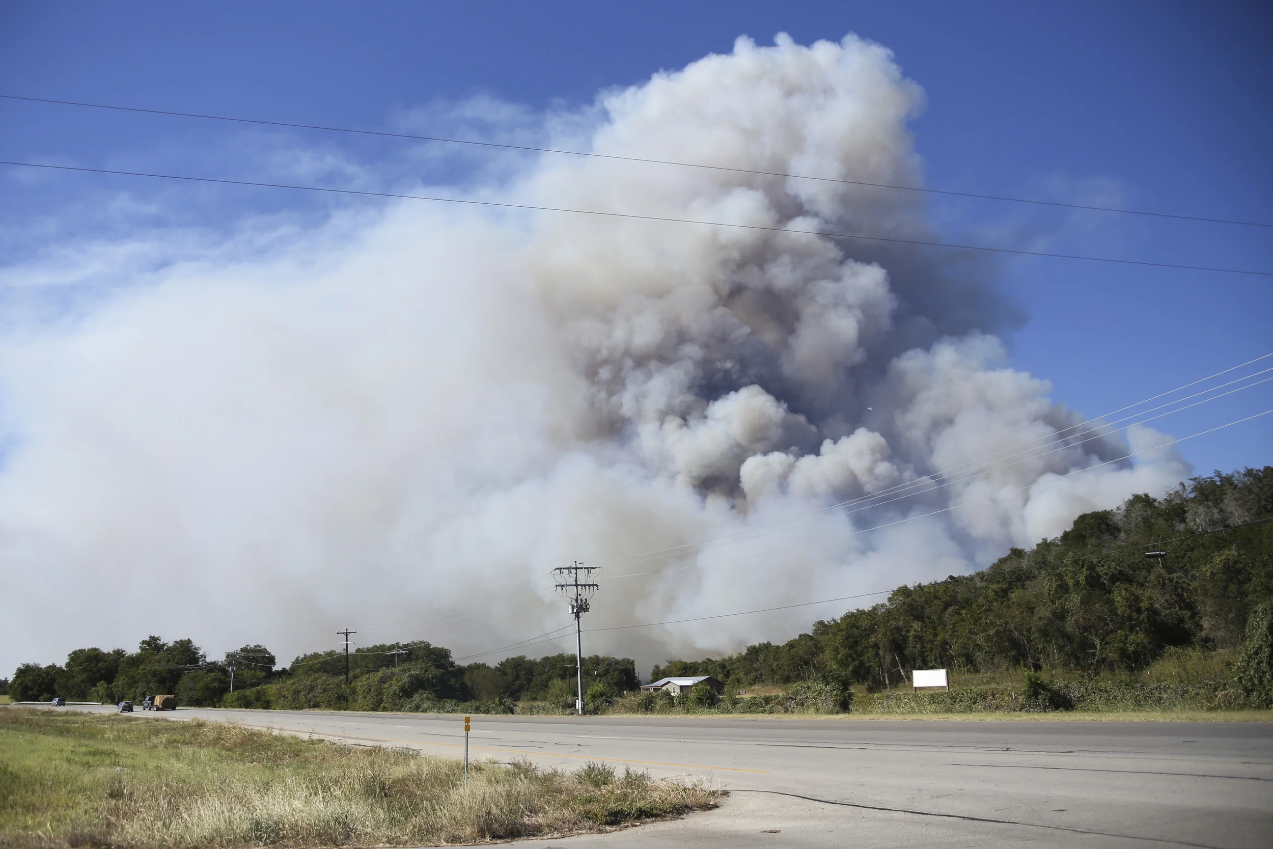 SMITHVILLE, TEXAS - Oct. 14, 2015: Large plumes of smoke rise from the north side of SH71. Miguel Gutierrez Jr. /KUT News.