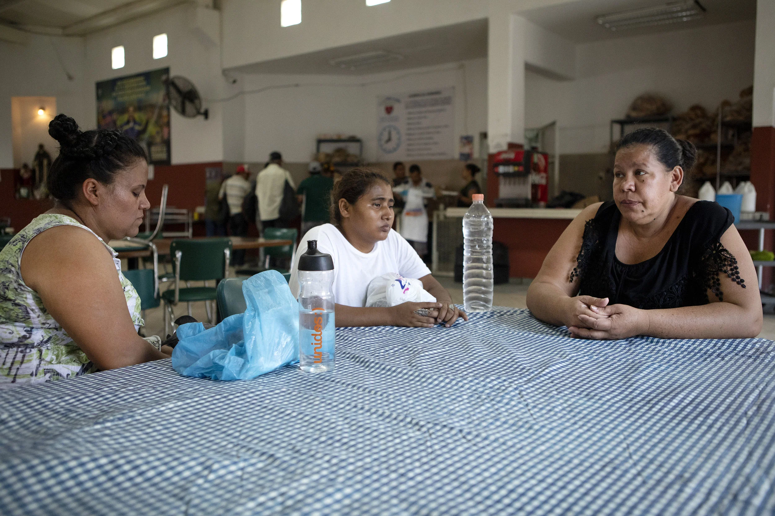Anjelica Zavala, dressed in black, sits at a table in the dining room at Casa INDI. According to Zavala, her parents, husband and cousins were murdered by gangs in El Salvador. Zavala has an asylum hearing scheduled for the fall. Aug. 6, 2019.
