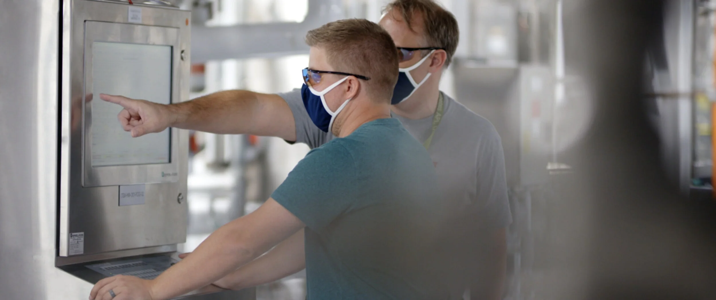 Fluor-Novo-Nordisk-Two-Masked-Men-using-Computer-Equipment-inside-Plant.jpg