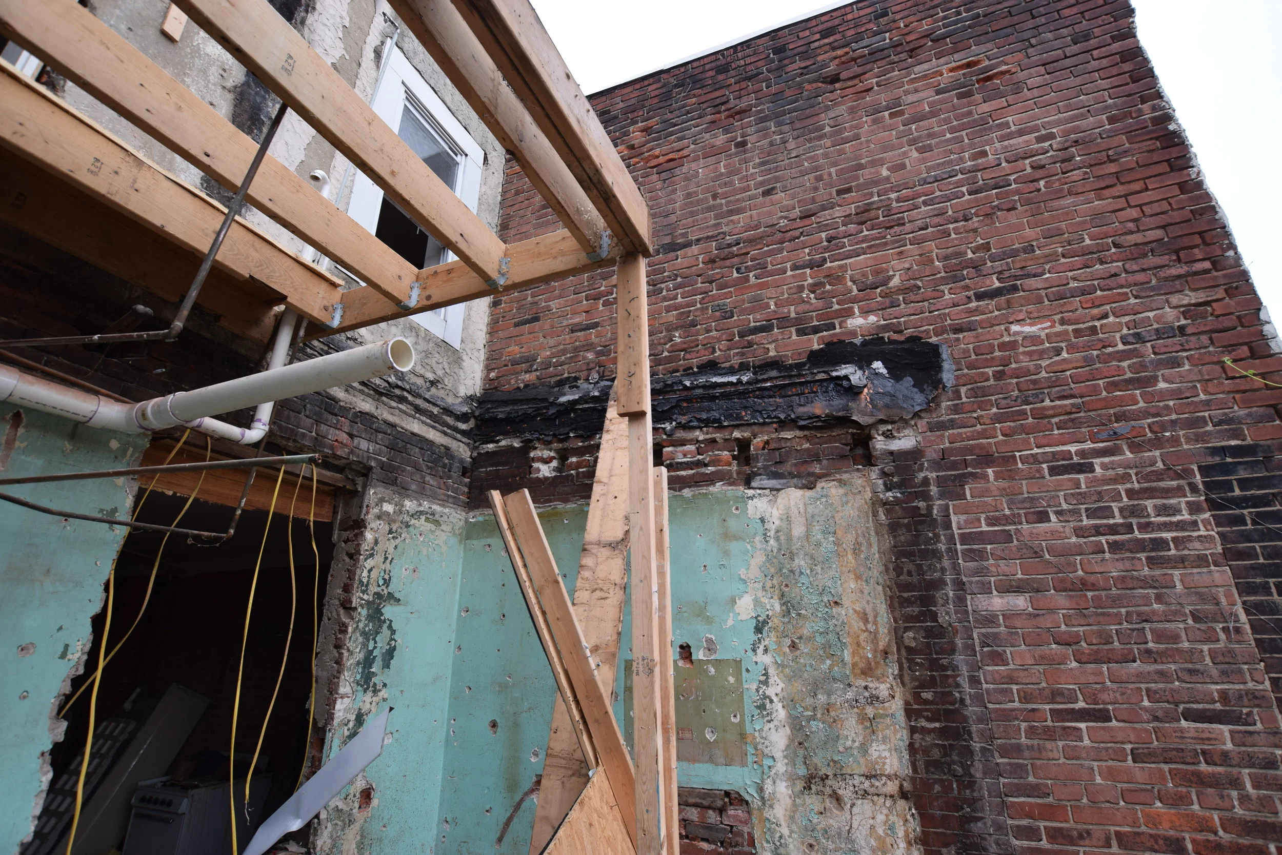 You can see the outline of the former addition imprinted on the neighbor's wall. Metal joist hangers in the former second-floor framing show that this was a modern addition.