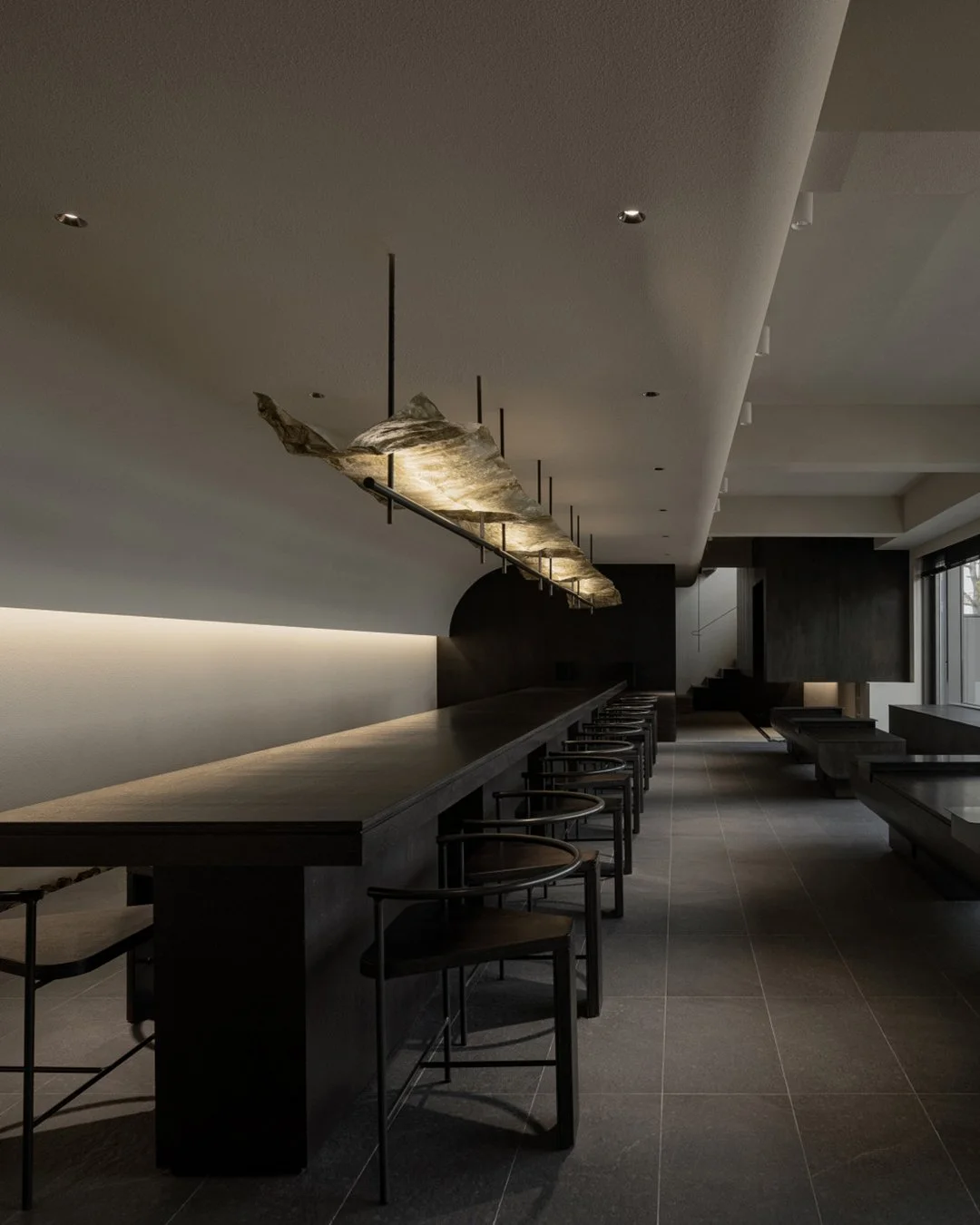 آچراغ توکار هالوژن هوبو برای فضای مدرن و مینیمال و حرفه ای با بهترین کیفیتModern restaurant interior with dark wood bar, black chairs, and contemporary lighting fixture, minimalistic design.