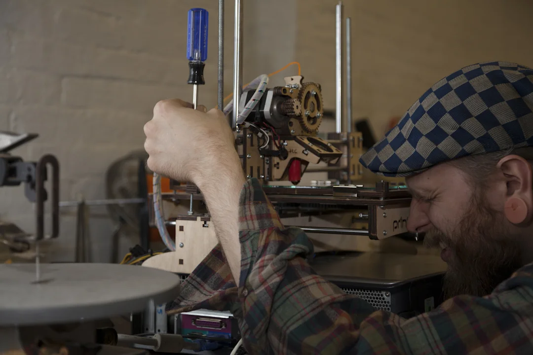 Kevin adjusting a 3D printer - photo by Andrew Harrington